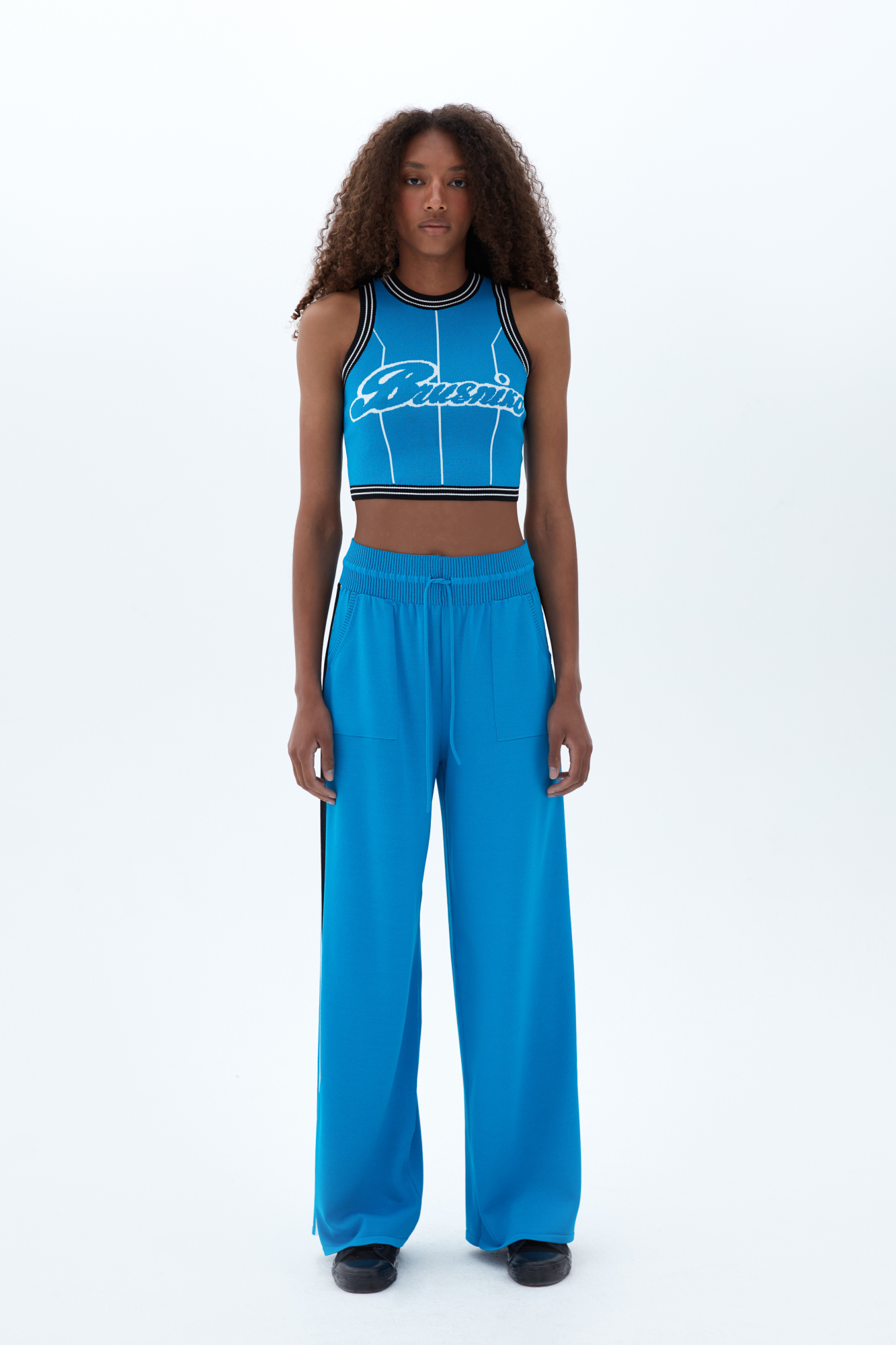 Широкие брюки из вискозы с двухцветным лампасом и надписью внизу. Пояс на эластичной ленте с кулиской и боковые карманы.