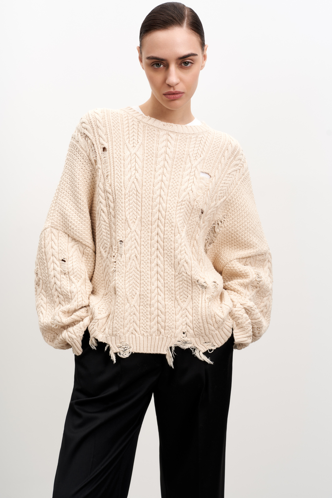 Трикотажный джемпер из вискозы с добавлением хлопка. Длинные рукава, круглый вырез, разрезы по всему изделию в стиле гранж.