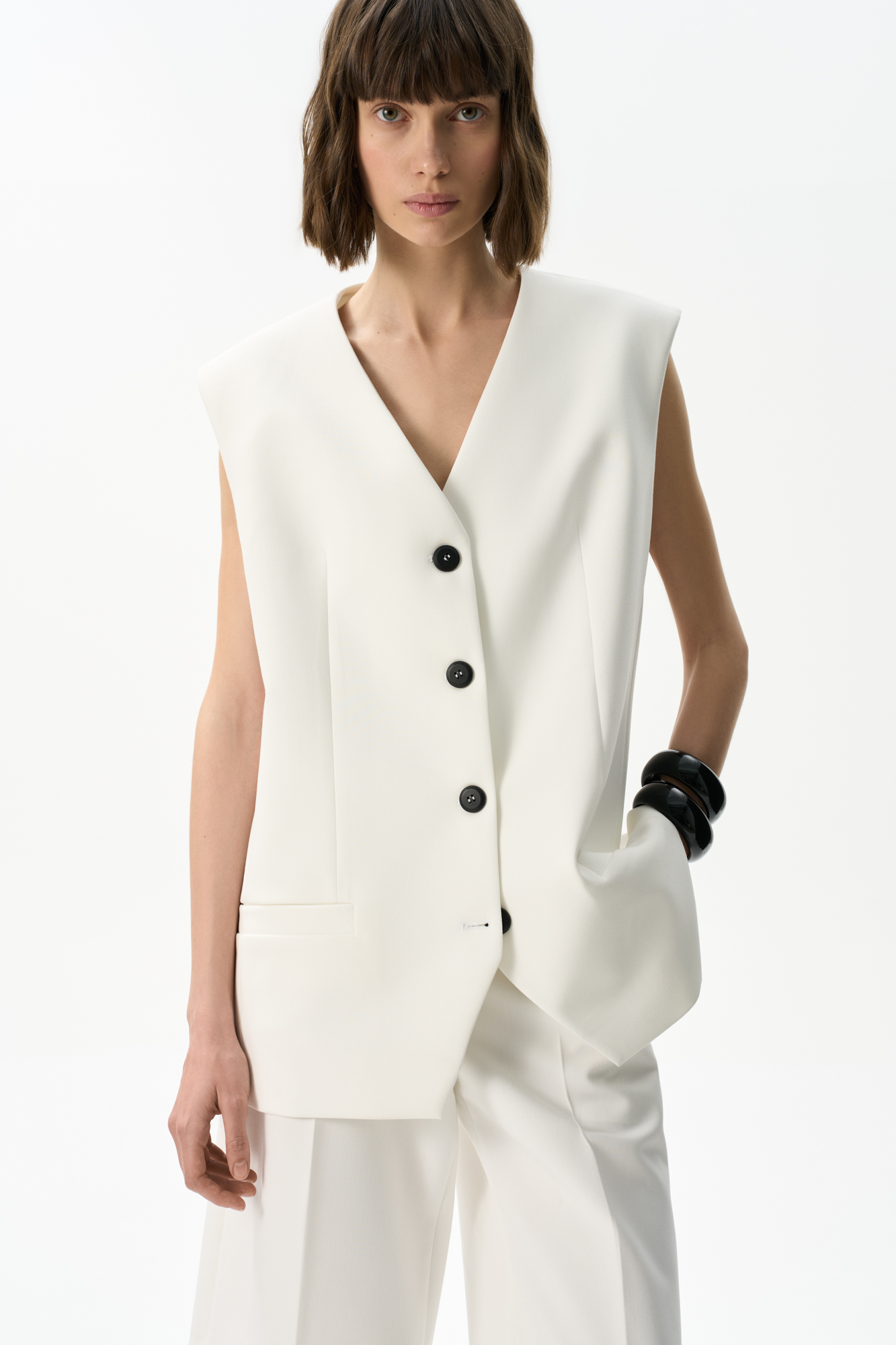 Классический жилет из поливискозы. Модель прямого кроя с имитацией карманов и V-образным вырезом. Изделие на подкладке. Застежка на пуговицы.