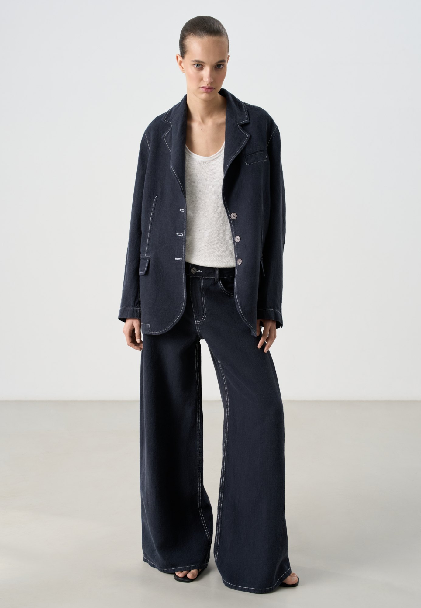 Классический однобортный жакет из 100% льна. Модель прямого кроя, с широкими лацканами и застежкой на три пуговицы. Нагрудный и два прорезных кармана с клапанами. Изделие декорировано строчкой контрастного цвета. 