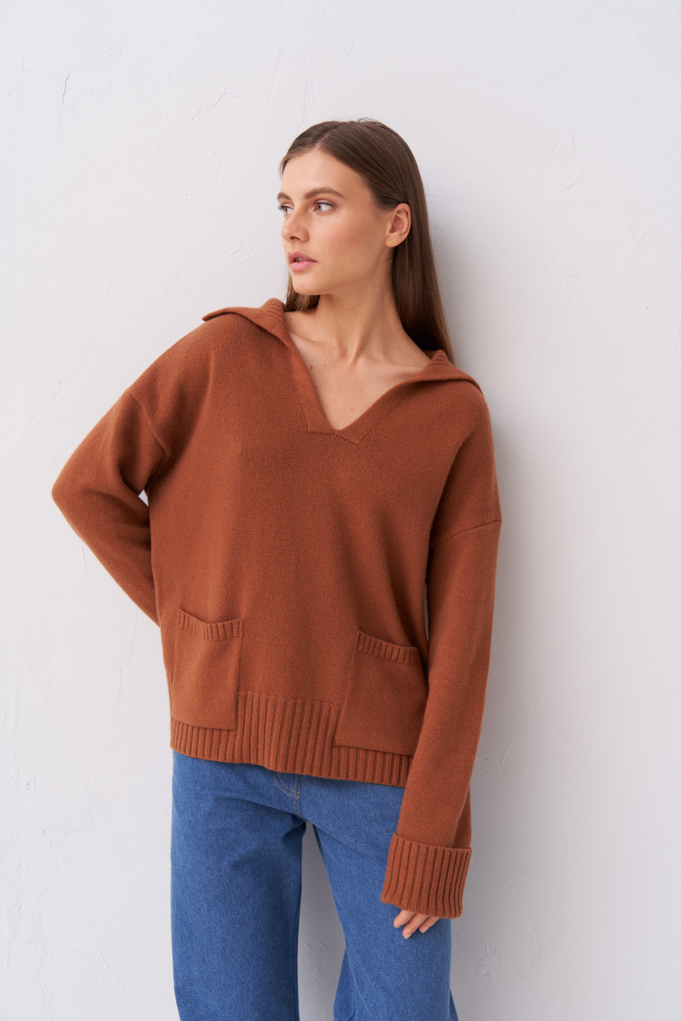 Трикотажный джемпер из шерсти с V-образным вырезом и отложным воротником. Модель свободного силуэта с накладными карманами.