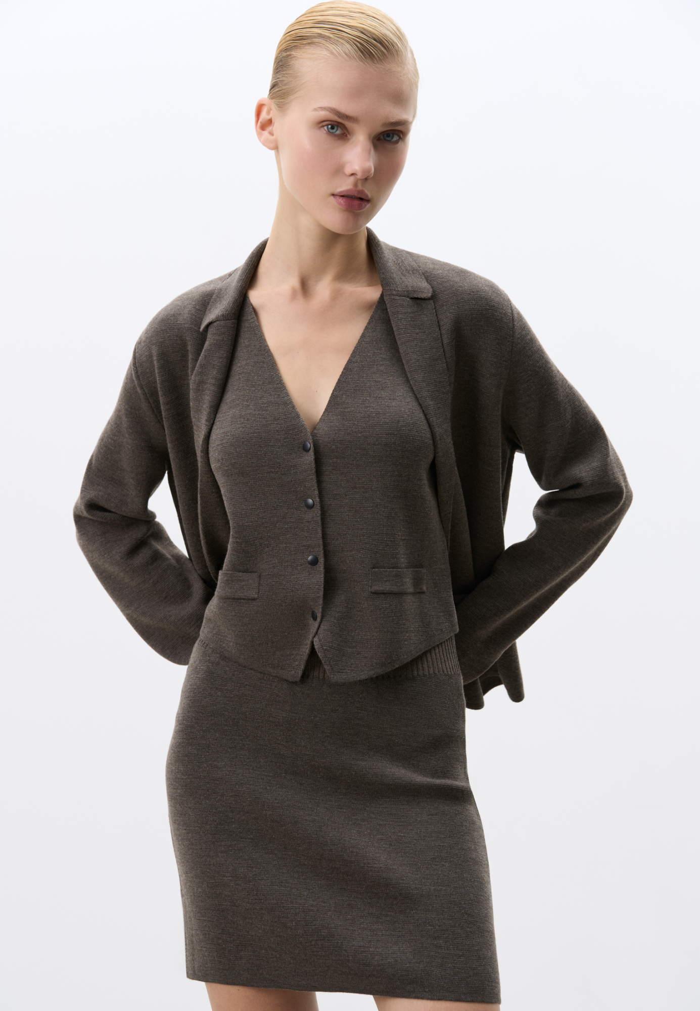 Трикотажный однобортный жилет из шерсти мериноса экстрафайн. Модель прямого кроя с имитацией карманов с клапанами и V-образным вырезом. Застежка на кнопки. Изделие без подкладки. Дополнить образ можно жакетом, бомбером, брюками или юбкой.