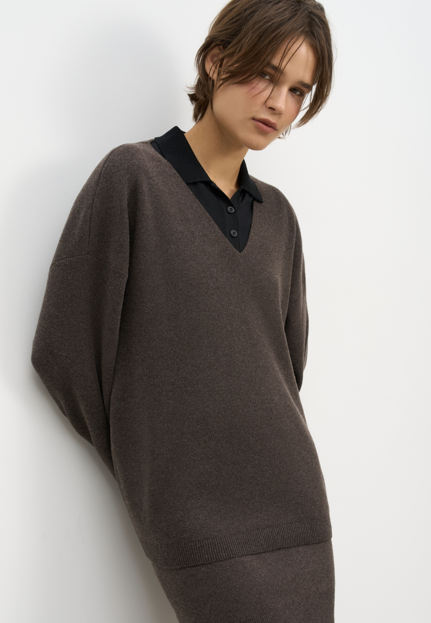 Трикотажный джемпер из шерсти с добавлением кашемира. Модель свободного силуэта со спущенной линией плеч и V-образным вырезом горловины. Манжеты рукавов и низ изделия выполнены в рубчик.