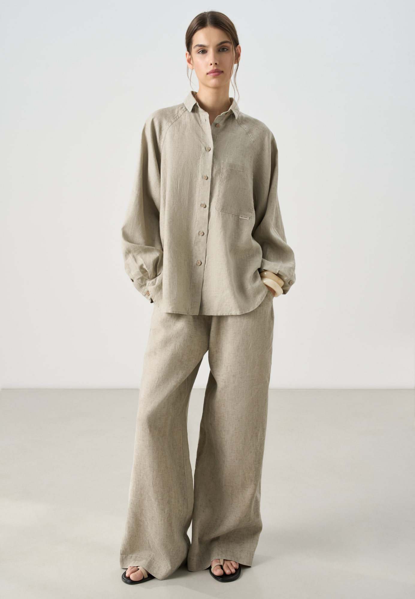 Рубашка из 100% льна. Модель свободного кроя, с длинным рукавом реглан, отложным воротником, нагрудным карманом и удлиненной спинкой. Застежка на пуговицы. 