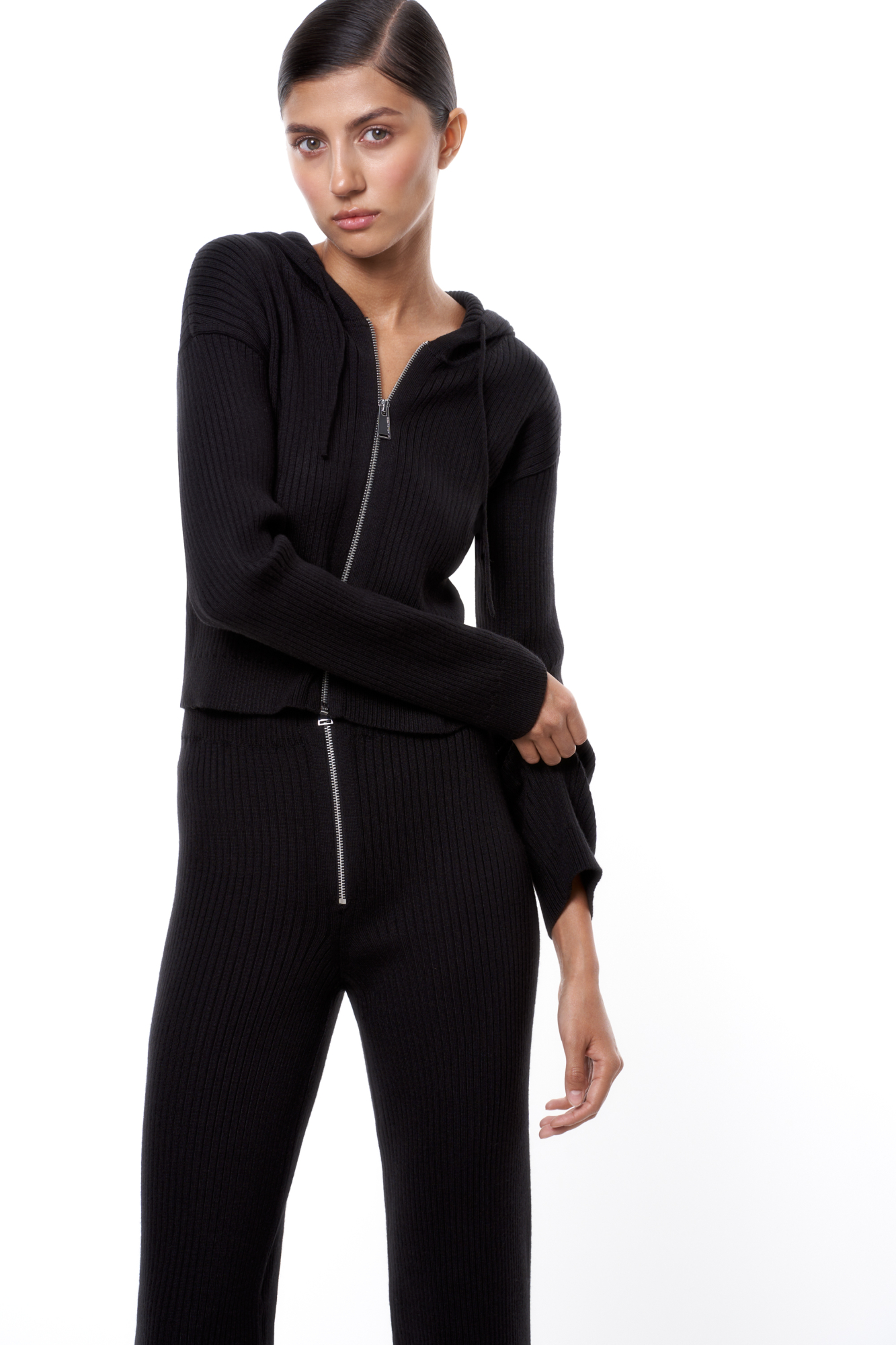 Трикотажный бомбер в рубчик. Модель приталенного силуэта, с длинными рукавами, спущенной линией плеч и капюшоном на кулиске. Застежка на молнию.