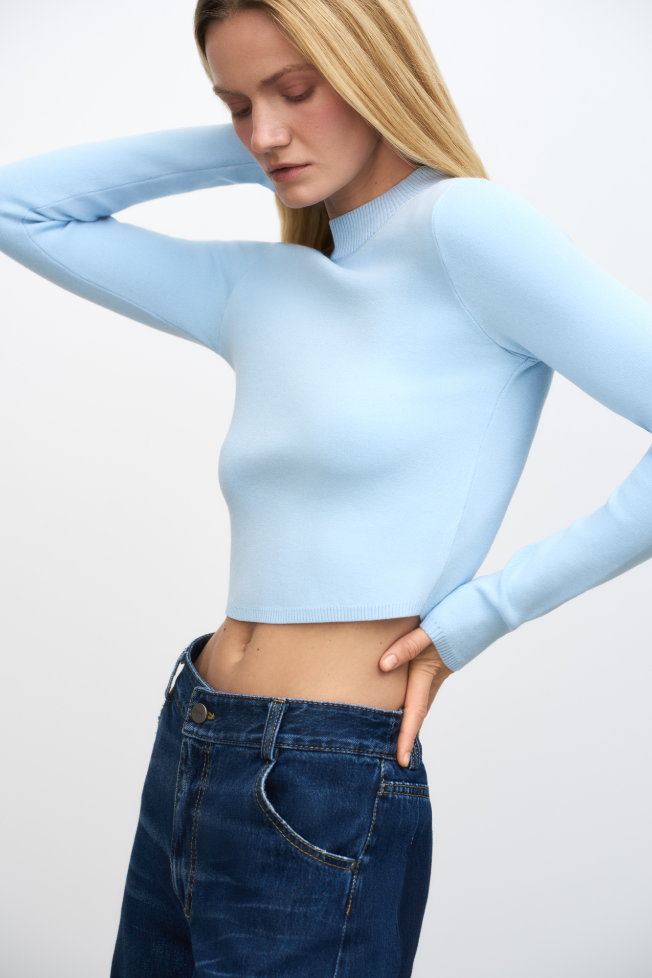 Трикотажный кроп-топ из вискозы с длинным рукавом, круглым вырезом горловины и фигурным низом. Края изделия выполнены в рубчик.