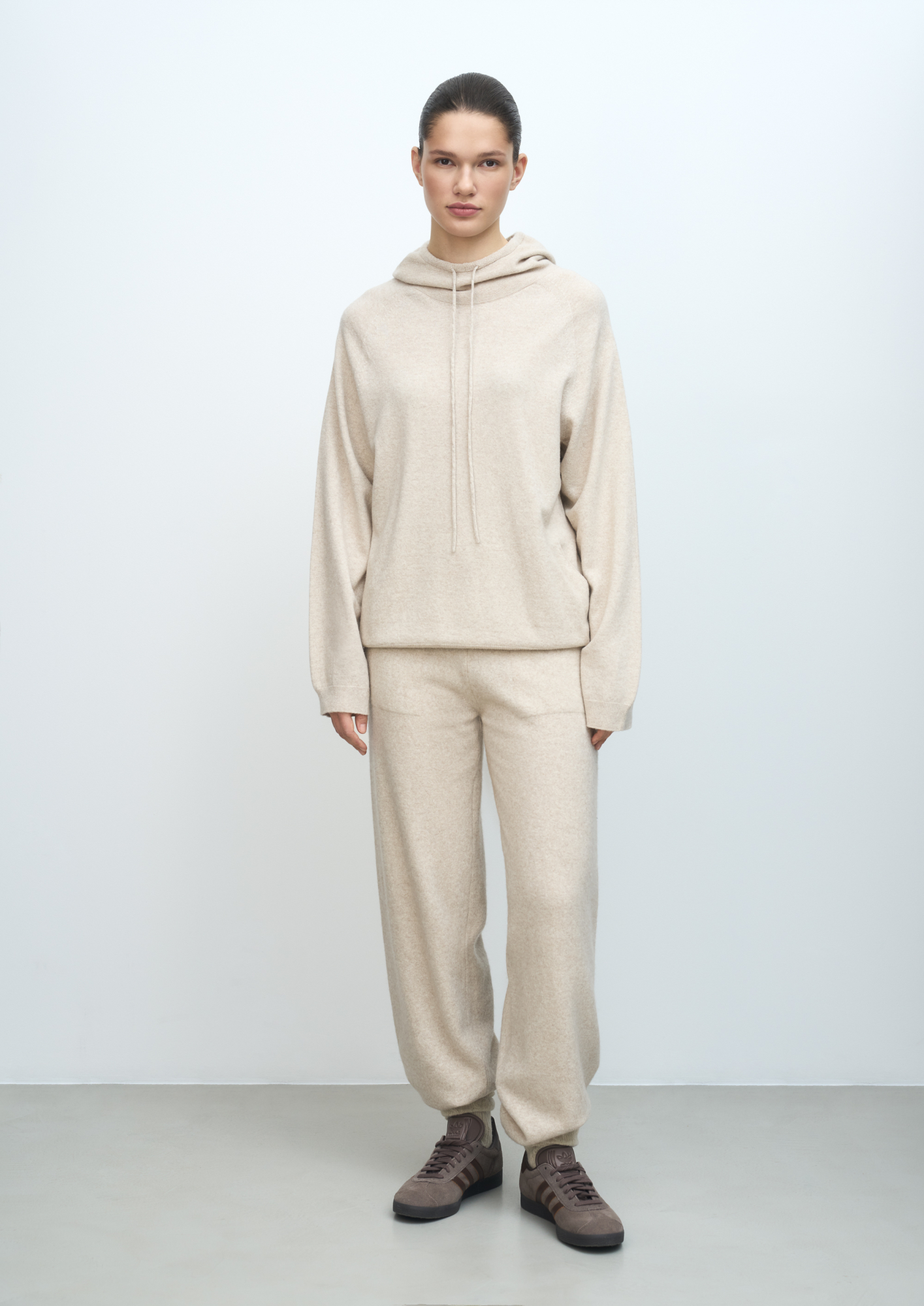 Трикотажные брюки из шерсти с добавлением кашемира. Модель свободного силуэта с эластичным поясом на кулиске и боковыми карманами. Манжеты брюк выполнены в рубчик. 