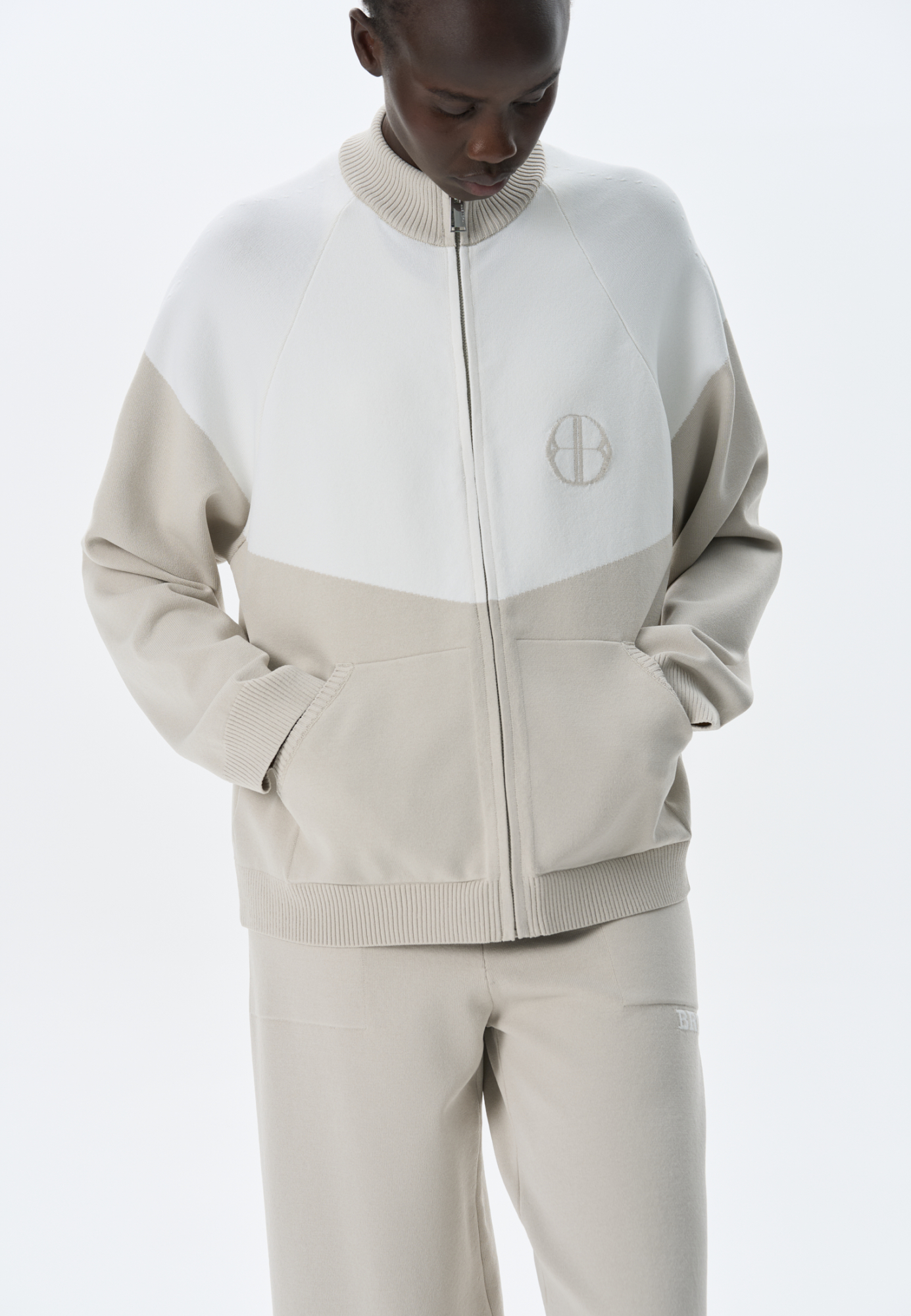 Трикотажный бомбер из вискозы с добавлением эластана. Модель прямого силуэта, с рукавом реглан, невысоким воротником-стойкой и боковыми карманами. Изделие декорировано брендированным жаккардом на груди. Застежка на молнию.