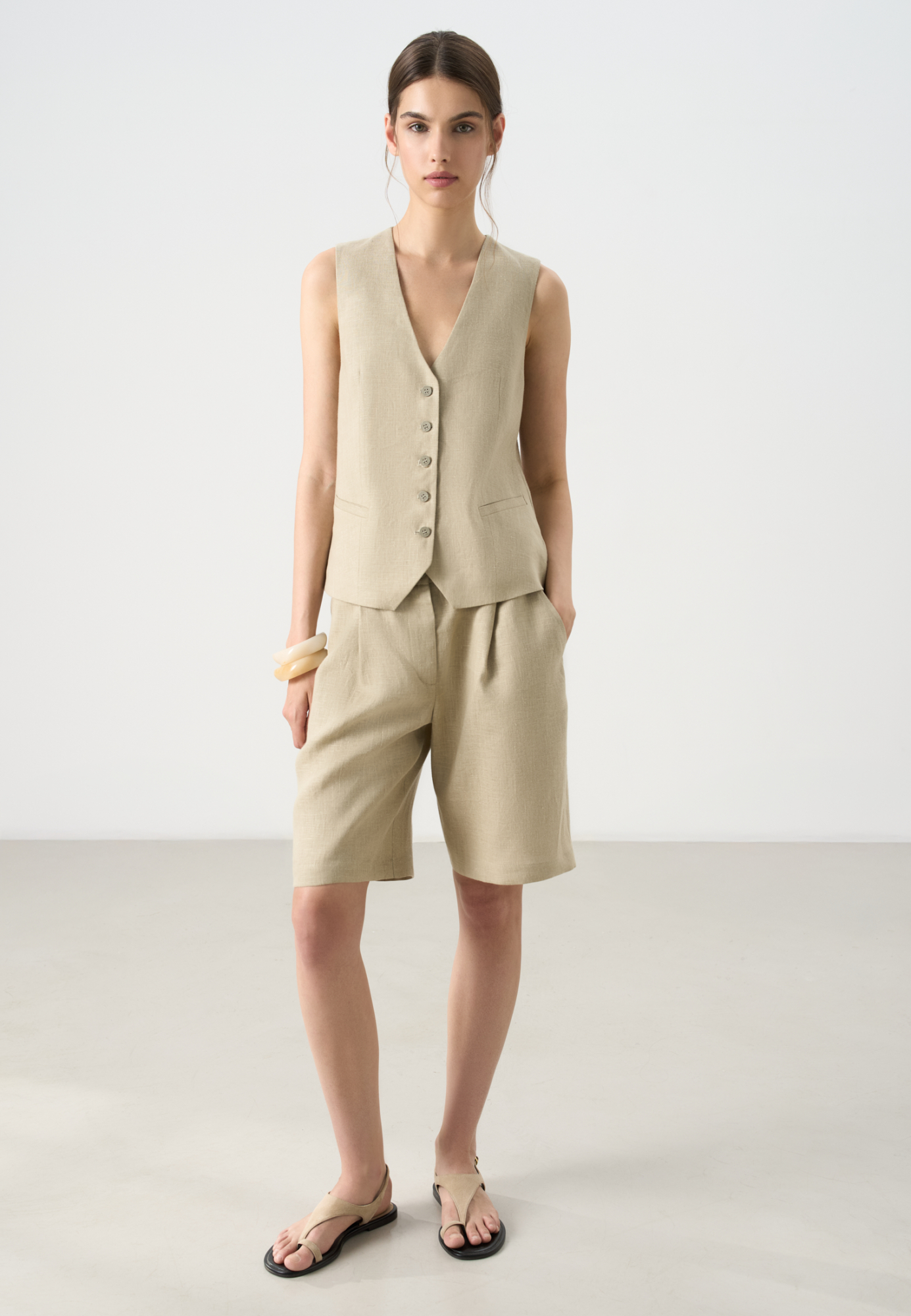 Шорты из 100% льна. Модель с высокой посадкой, широкими штанинами и складками спереди. Два кармана спереди и сзади. Застежка на пуговицу и молнию. Шлевки на поясе для ремня.