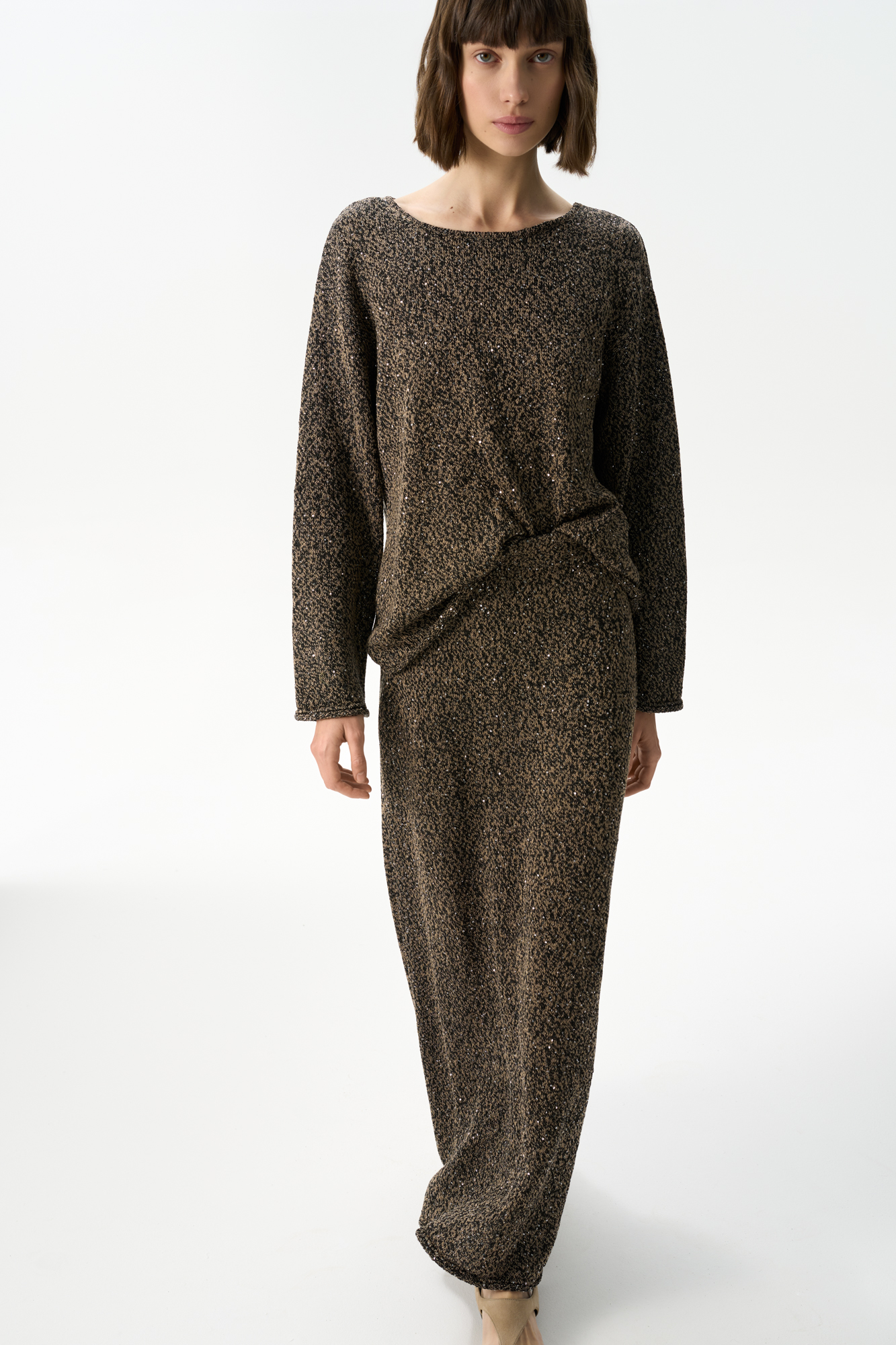 Трикотажная юбка длины макси из хлопка с добавлением вискозы. Модель А-силуэта, с широким эластичным поясом на резинке. Изделие декорировано маленькими пайетками.