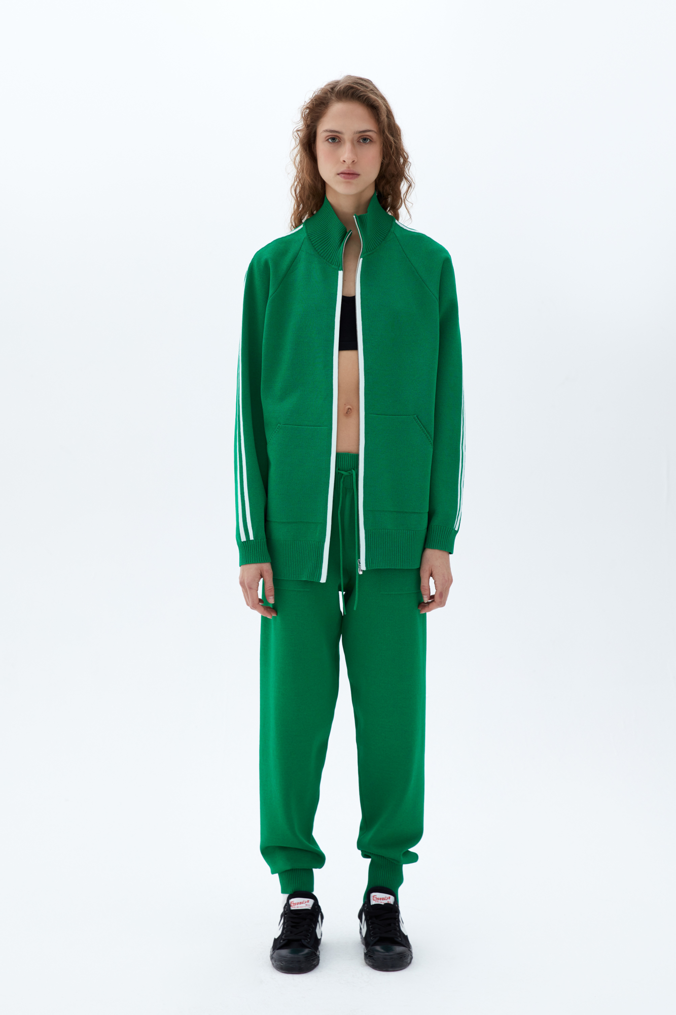 Трикотажыне спортивные брюки. Модель прямого кроя с высокими эластичными манжетами, выполненными в рубчик, регулируемым поясом на кулиске и боковыми карманами.