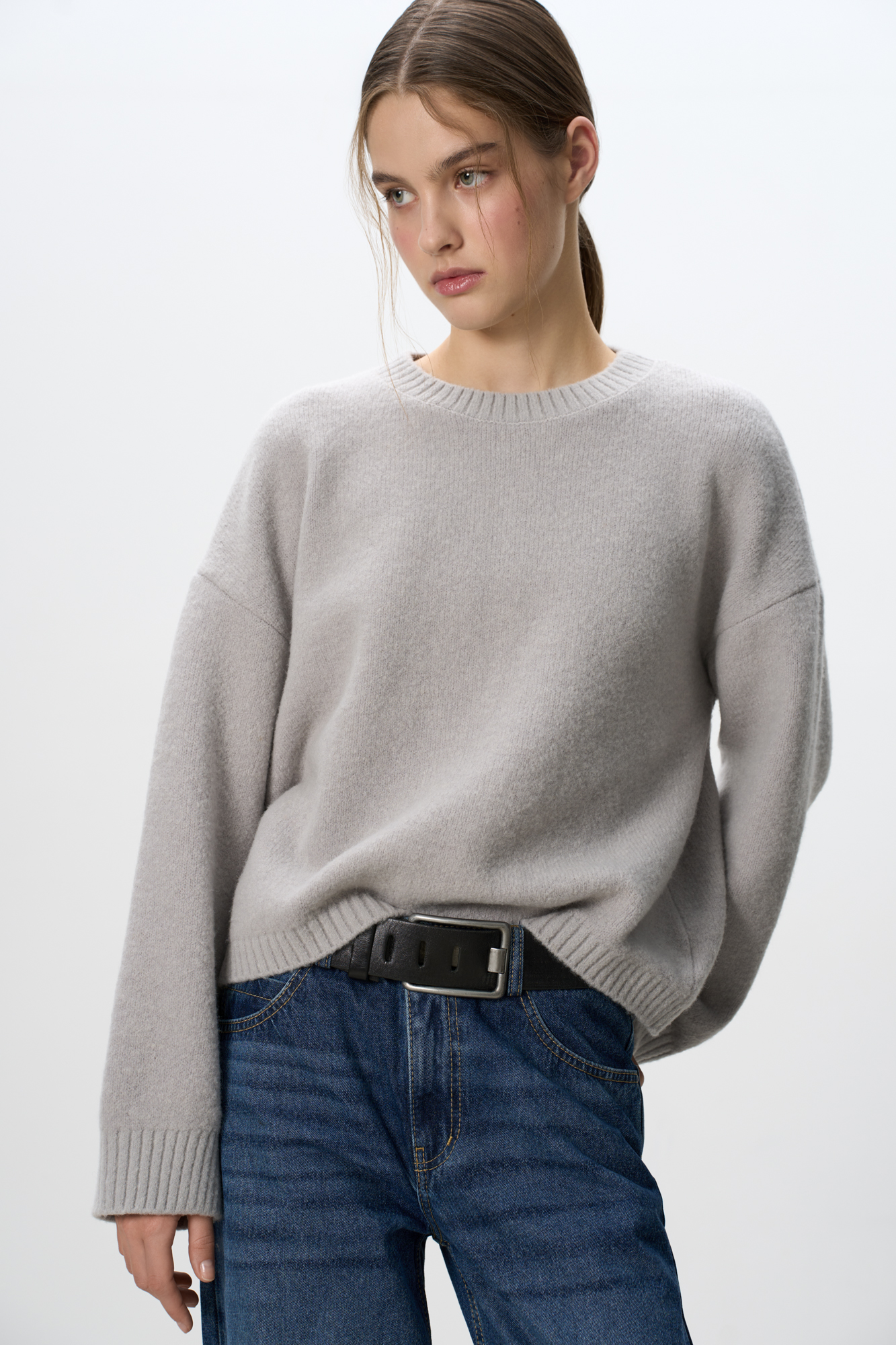 Трикотажный джемпер из смесовой шерсти с добавлением мохера. Модель свободного силуэта со спущенной линией плеч и круглым вырезом горловины. Края изделия выполнены в рубчик. Дополнить образ можно юбкой.