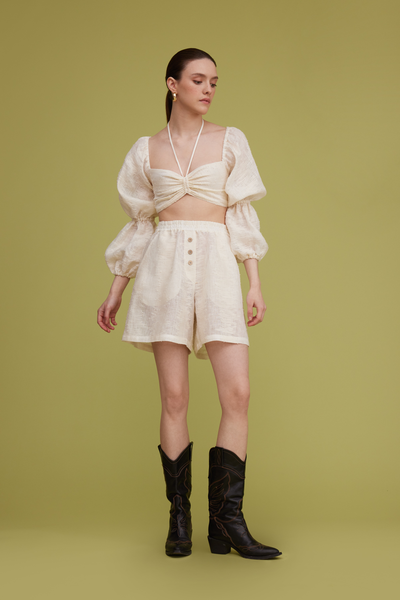 Шорты из текстурного льна. Модель прямого кроя с поясом на резинке, двумя карманами и декором в виде пуговиц.