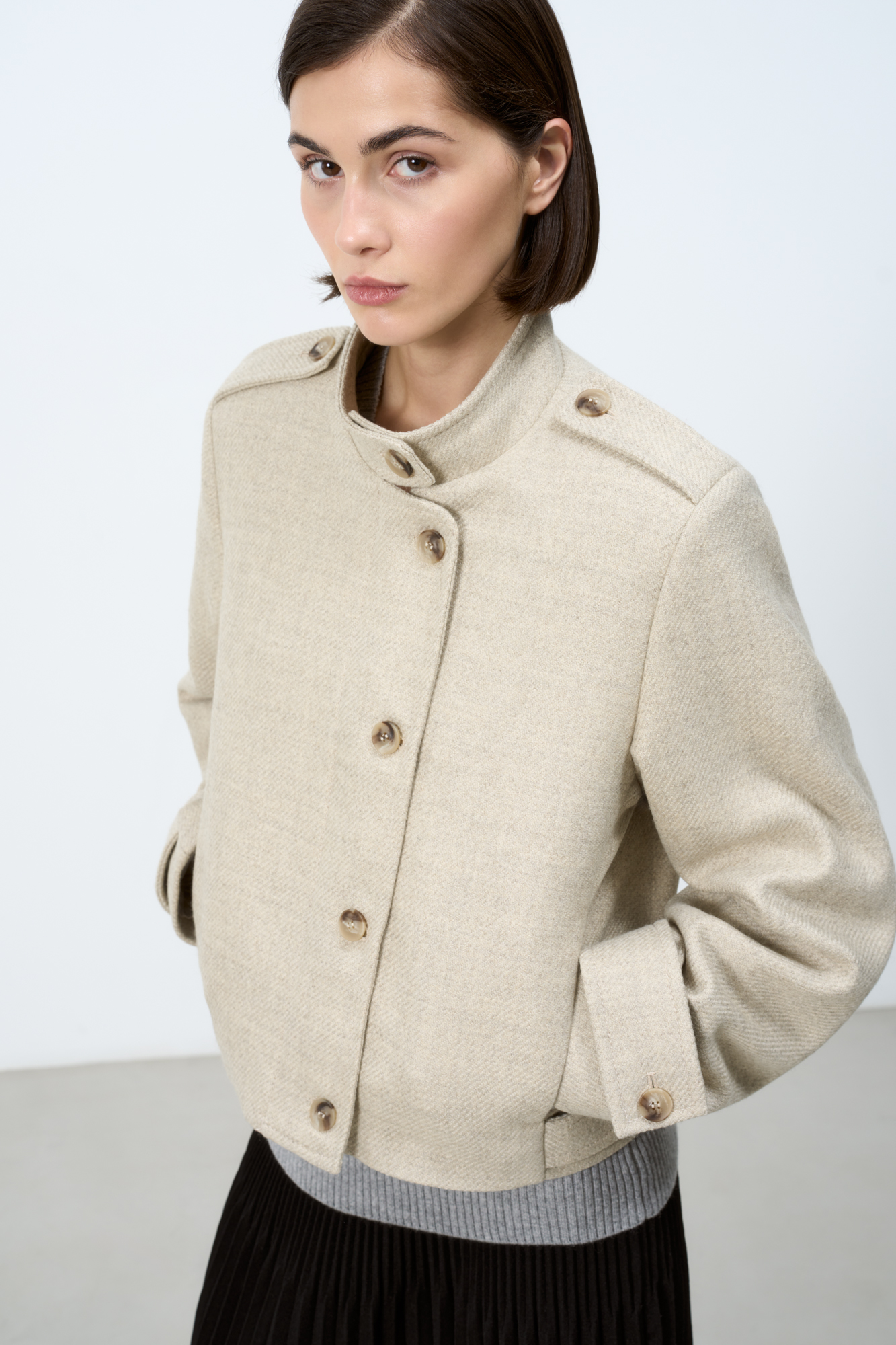 Шерстяной бомбер с воротником-стойкой. Манжеты рукавов декорированы патами и пуговицами. Застежка на пуговицы. На подкладке.