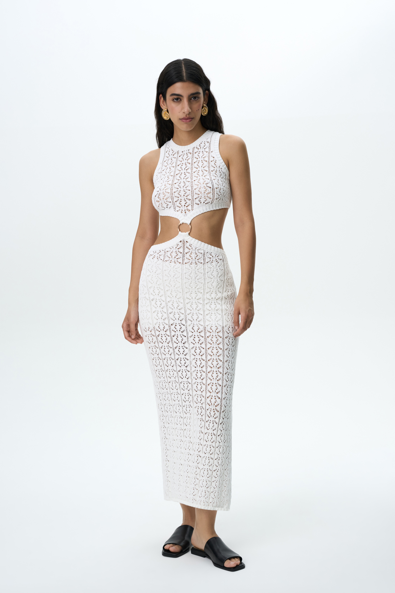 Трикотажный ажурный сарафан из хлопка с добавлением эластана. Модель без рукавов, с круглым вырезом горловины. Сарафан декорирован кольцом, соединящим верх и юбку изделия. Края выполнены в рубчик.