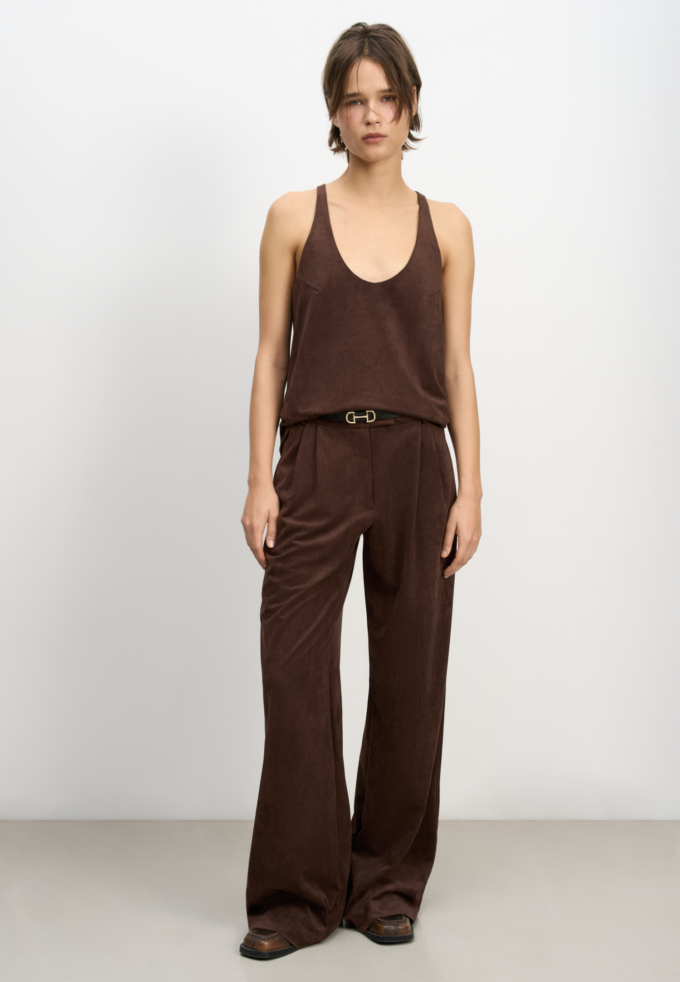 Топ из ткани с имитацией внешнего вида и свойств натуральной замши. Модель свободного силуэта на тонких бретельках и глубоким вырезом декольте.