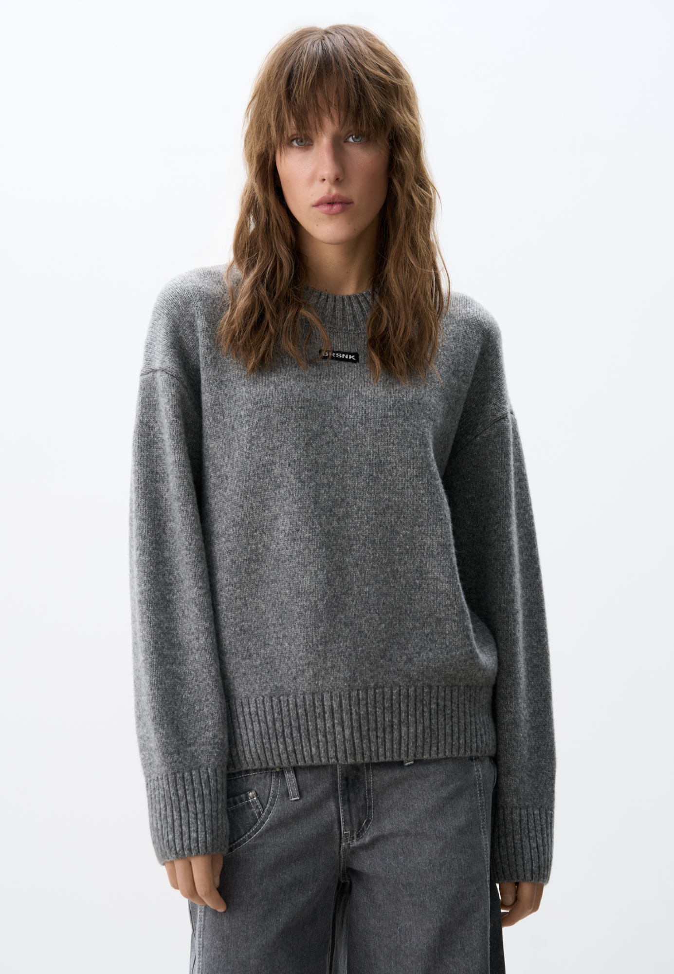 Объемный джемпер из шерсти с добавлением кашемира. Модель свободного силуэта, со спущенной линией плеч. Воротник выполнен изнаночными петлями в широкий рубчик. Манжеты рукавов и низ изделия - на резинке. Джемпер декорирован брендированным трикотажным ярлычком.