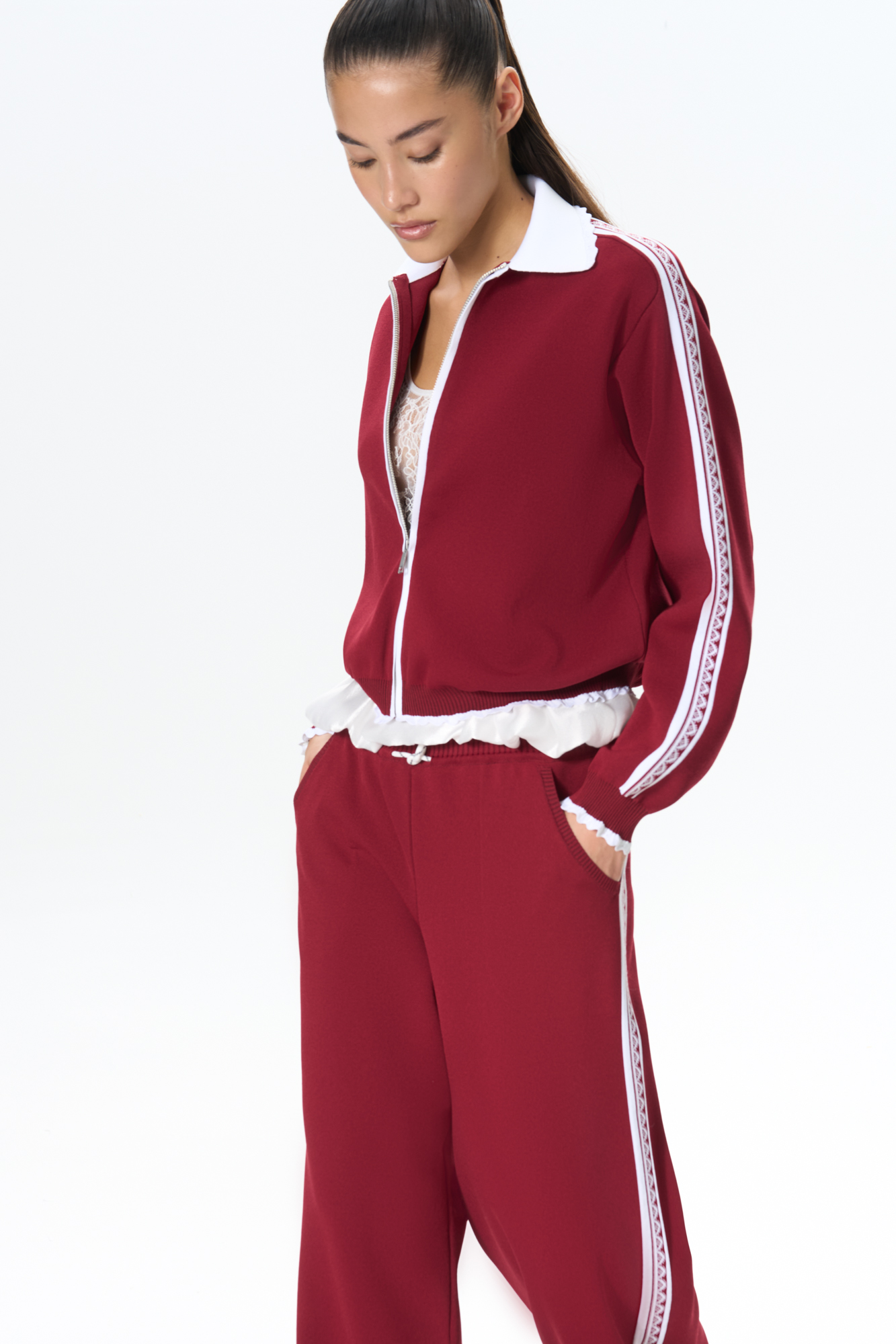 Трикотажный бомбер из вискозы. Модель свободного силуэта с ажурным отложным воротником, спущенной линией плеч и застежкой на молнию. Низ изделия и манжеты рукавов выполнены на резинке и дополнены кружевом. Изделие декорировано жаккардовым узором в виде кружева на рукавах.