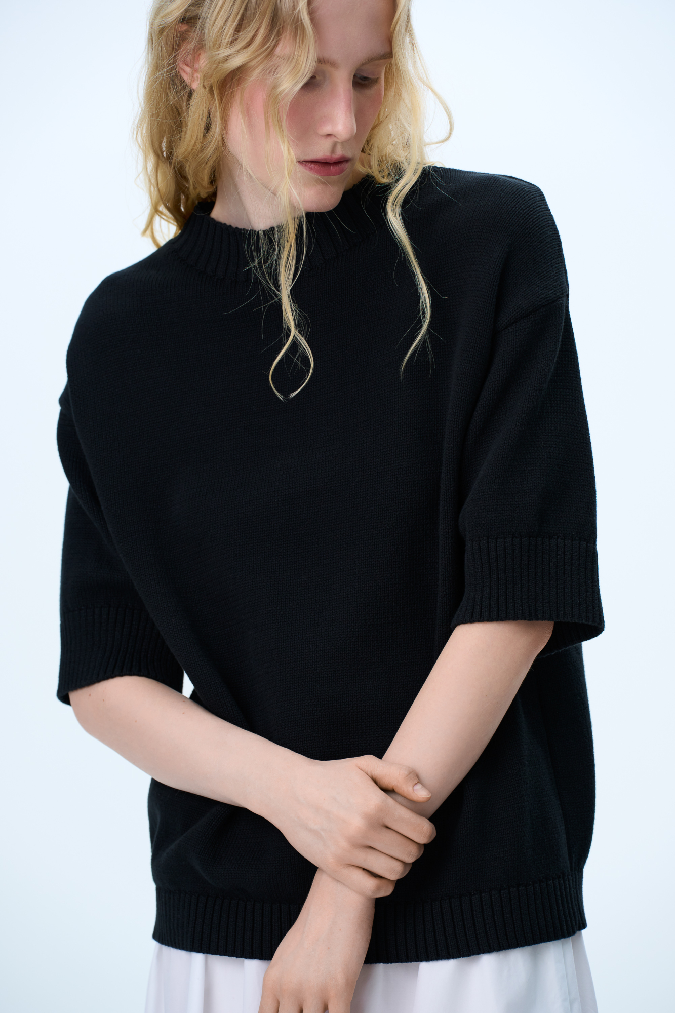 Трикотажная футболка из хлопка. Модель свободного силуэта со спущенной линией плеча, коротким рукавом и круглым вырезом горловины. Воротник, манжеты рукавов и низ изделия выполнены в широкий рубчик.