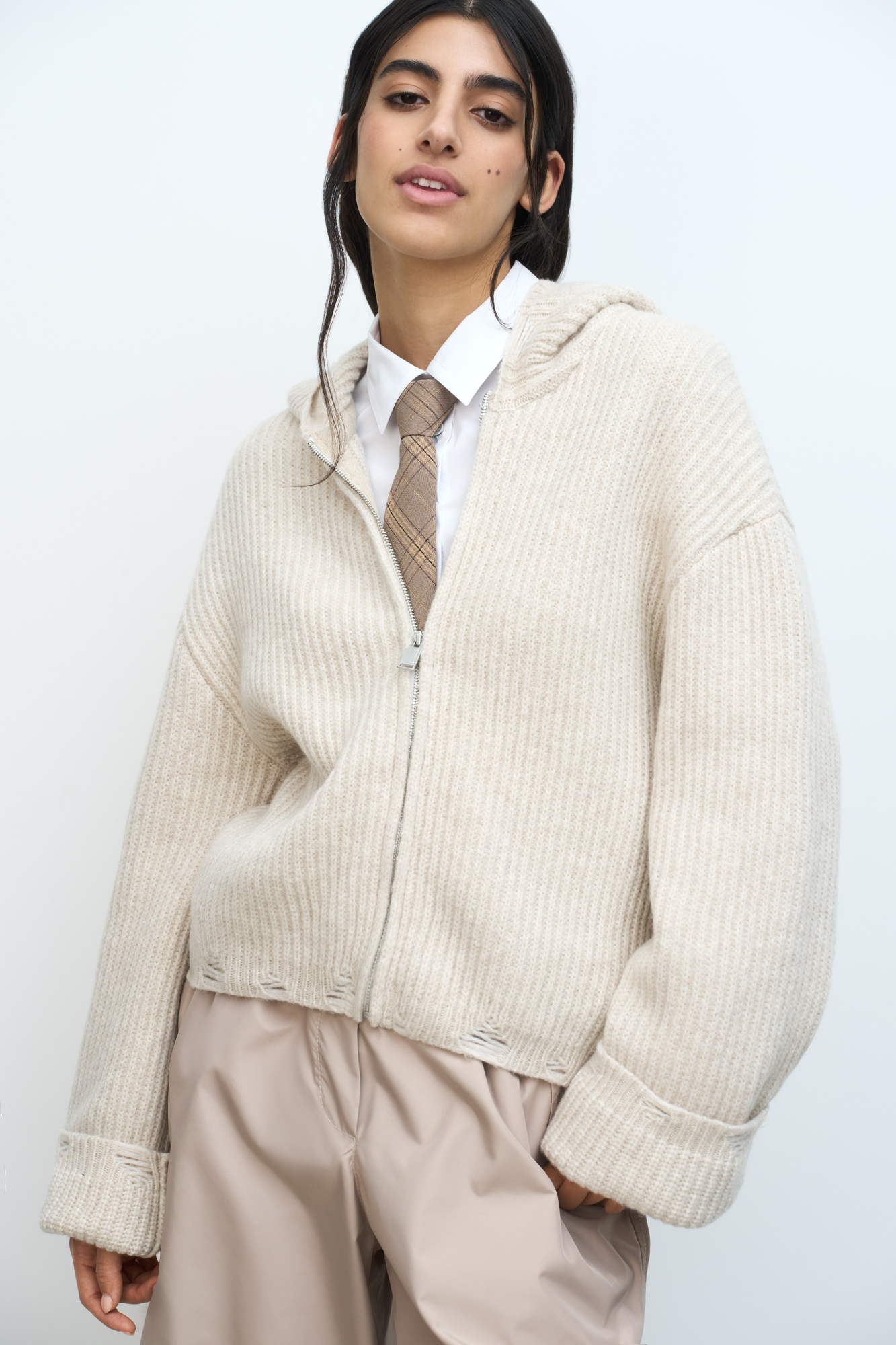 Трикотажное худи из шерсти мериноса. Модель свободного силуэта с разрезами в стиле гранж, длинными рукавами и капюшоном. Застежка на молнию.