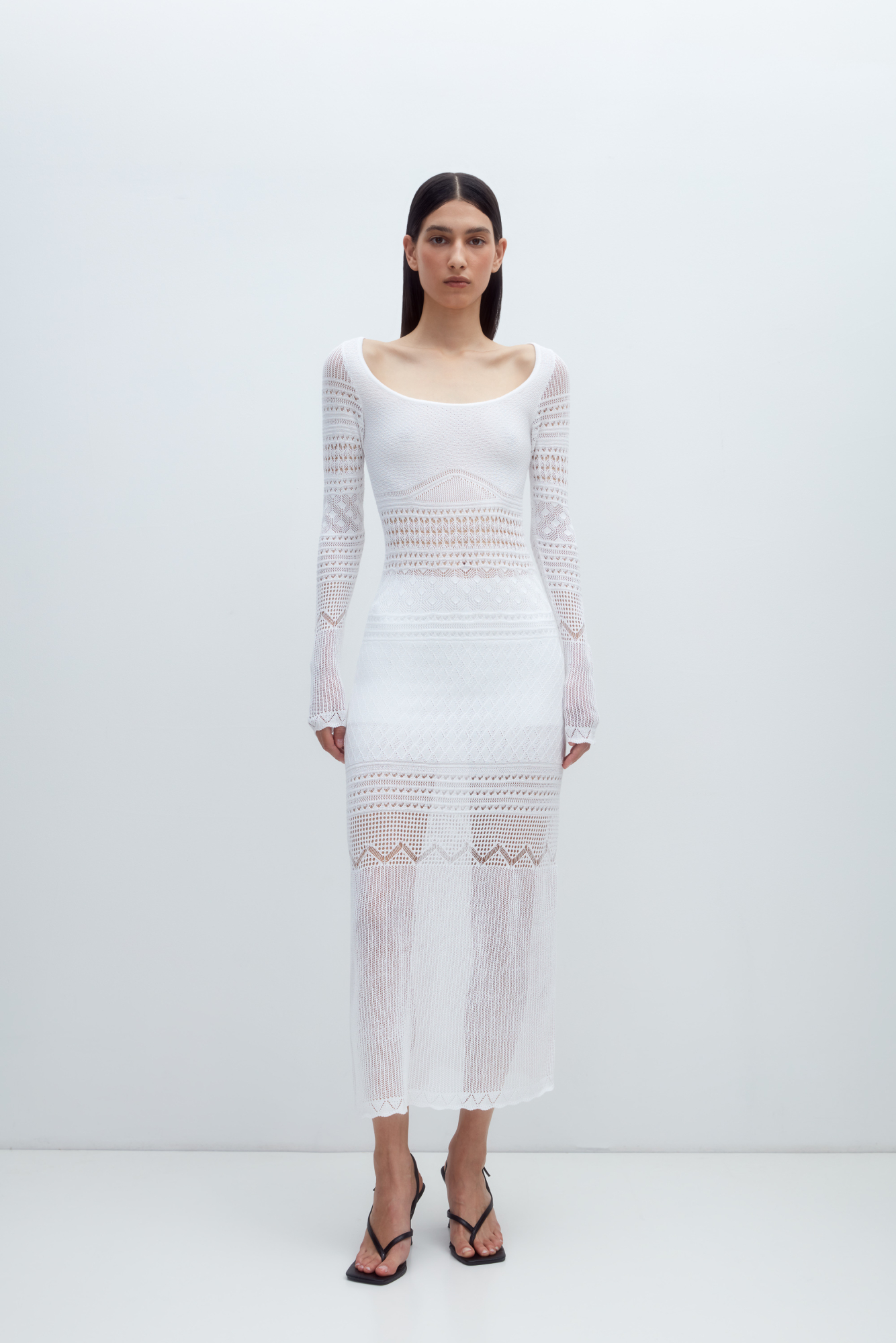 Трикотажное ажурное платье с геометрическими узорами длины миди. Модель с глубоким вырезом лодочкой, открывающим линию ключиц и длинными рукавами.&nbsp;&nbsp;