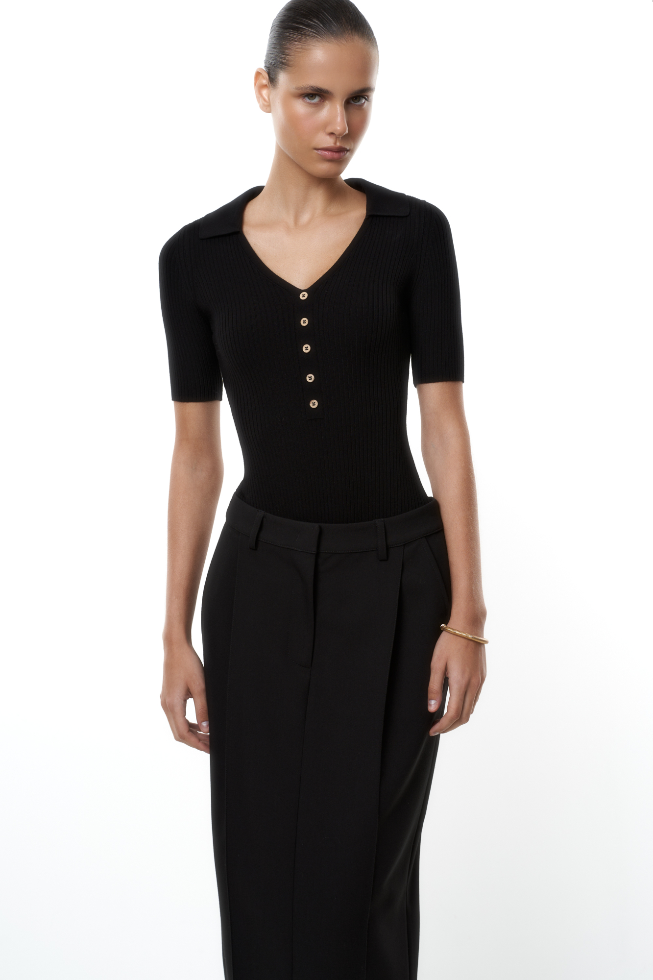 Трикотажное боди из вискозы в рубчик. Модель V-образный вырезом горловины, отложным воротником и коротким рукавом. Изделие декорировано небольшими пуговицами. Застежка на бельевые крючки.