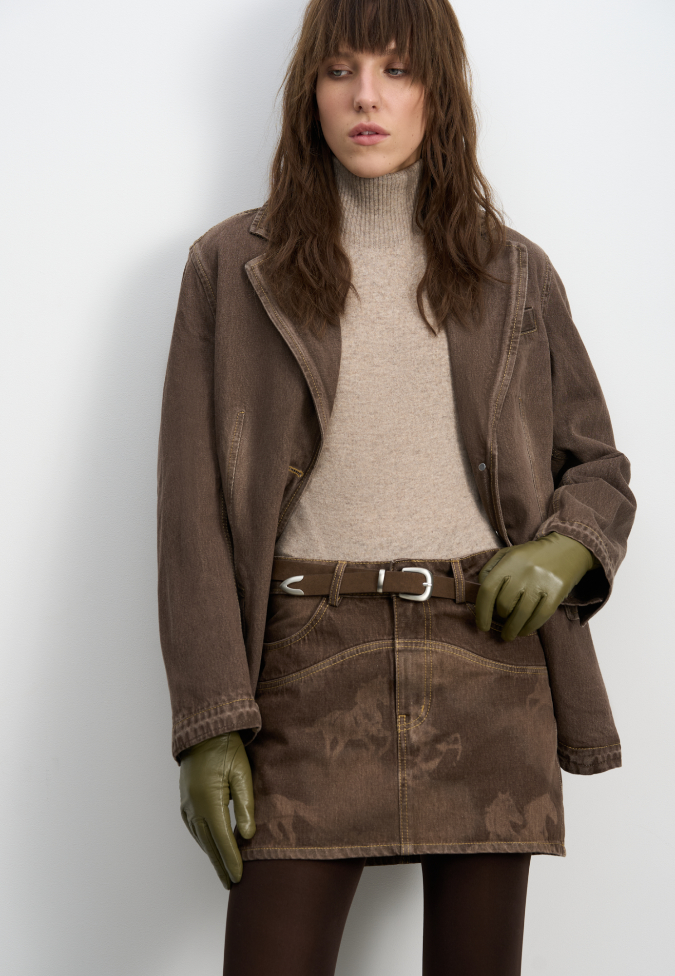 Джинсовая юбка длины мини из 100% хлопка с принтом лошадей. Модель с геометрическими вытачками, боковыми и задними карманами, шлевками на поясе для ремня и застежкой на металлические пуговицы с логотипом бренда. Изделие декорировано принтом лошадей и подковы, выполненным лазером, и объемными геометрическими вытачками.<br />
Модель в стиле дерби - направления в моде, которое имитирует одежду для скачек.