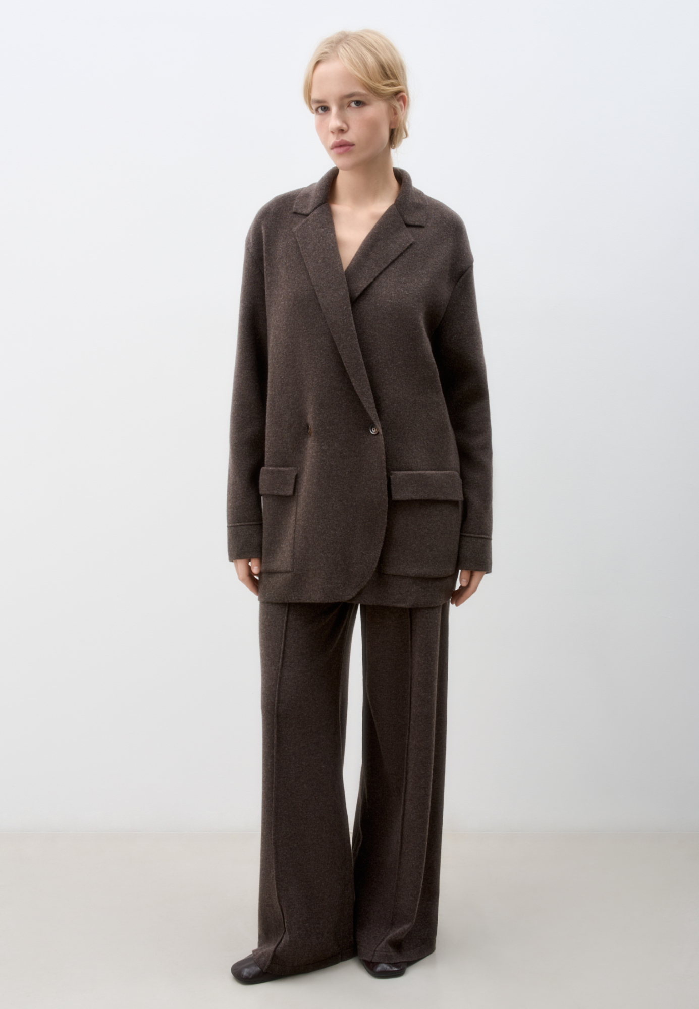 Трикотажный двубортный жакет из смесовой шерсти с добавлением кашемира. Модель прямого кроя, с прямоугольными лацканами и накладными карманами с клапанами спереди. Изделие без подкладки.