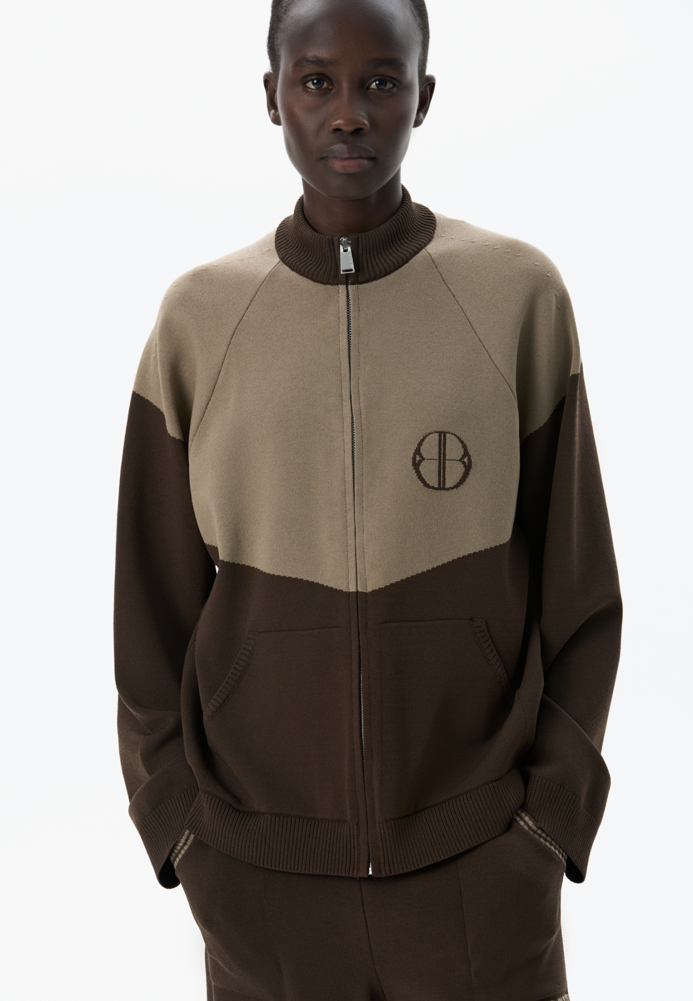 Трикотажный бомбер из вискозы с добавлением эластана. Модель прямого силуэта, с рукавом реглан, невысоким воротником-стойкой и боковыми карманами. Изделие декорировано брендированным жаккардом на груди. Застежка на молнию.