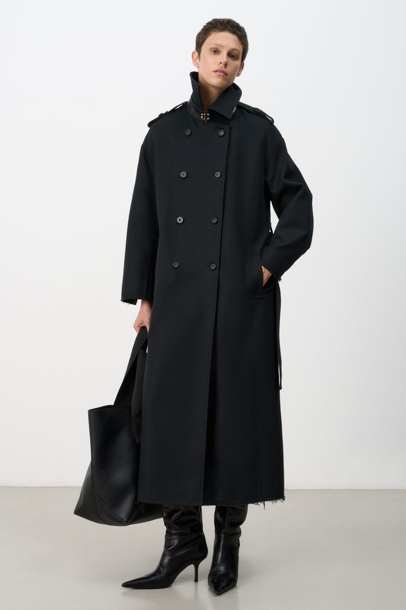 Двубортный oversize плащ с необработанными краями. Асимметричная отлетная кокетка, отложной воротник и широкий пояс из основного материала. На подкладке.