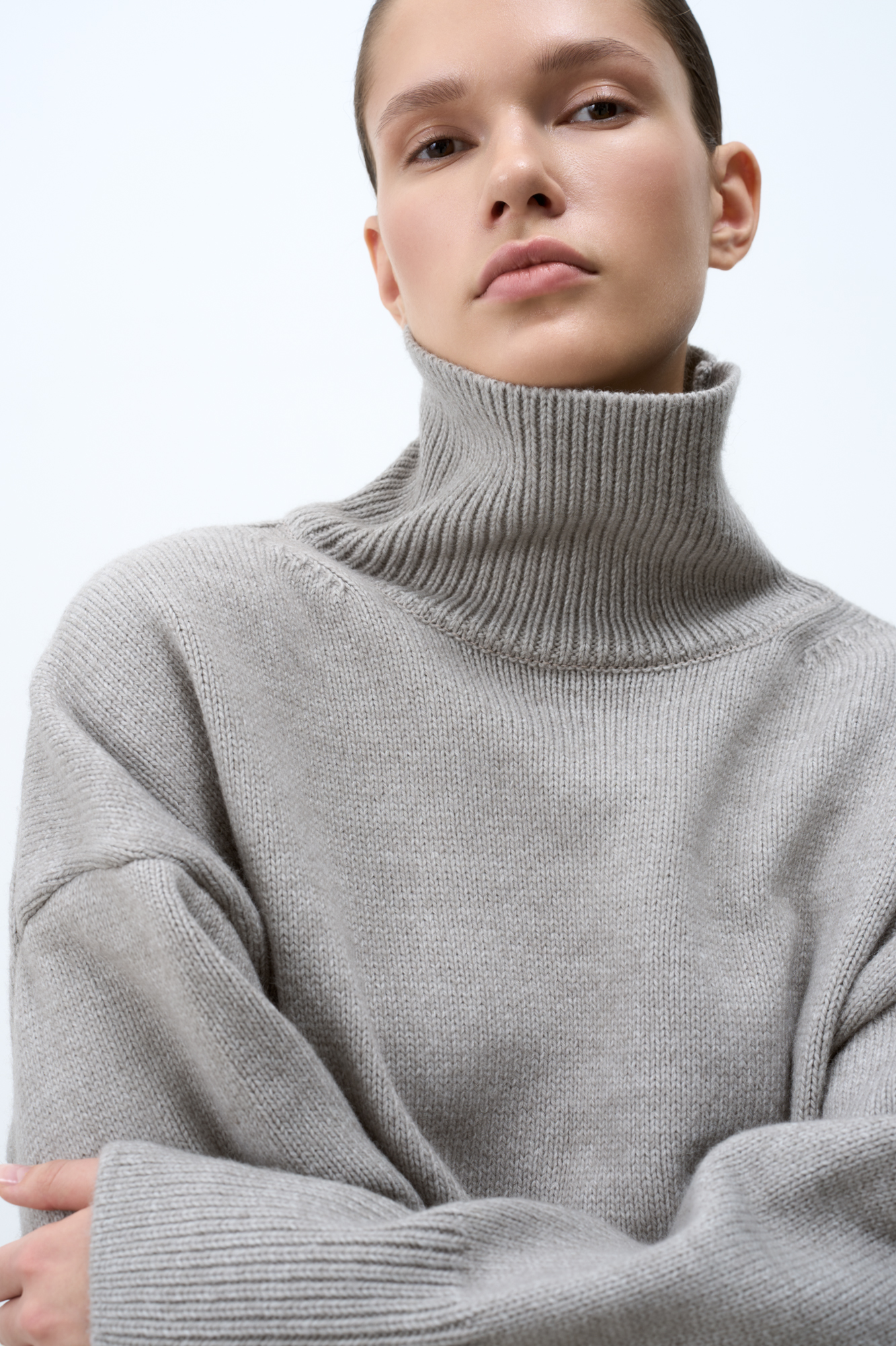 Трикотажный джемпер с шерстью альпака. Модель свободного силуэта с высоким воротником, спущенной линией плеча и длинными рукавами. Манжеты и низ изделия в рубчик.