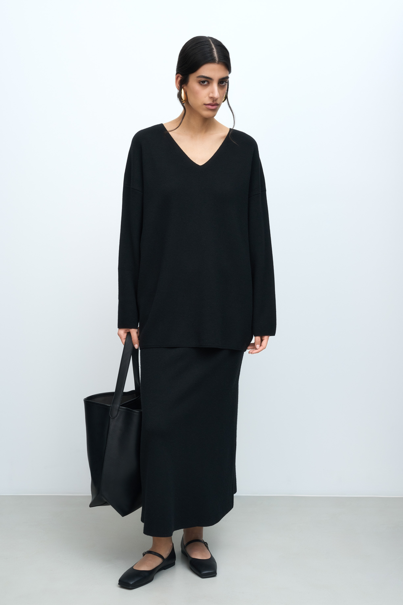 Трикотажная юбка длины миди, выполненная из смесовой шерсти с добавлением кашемира. Модель расклешенного силуэта, с широким эластичным поясом со шлевками и двумя накладными карманами сзади.