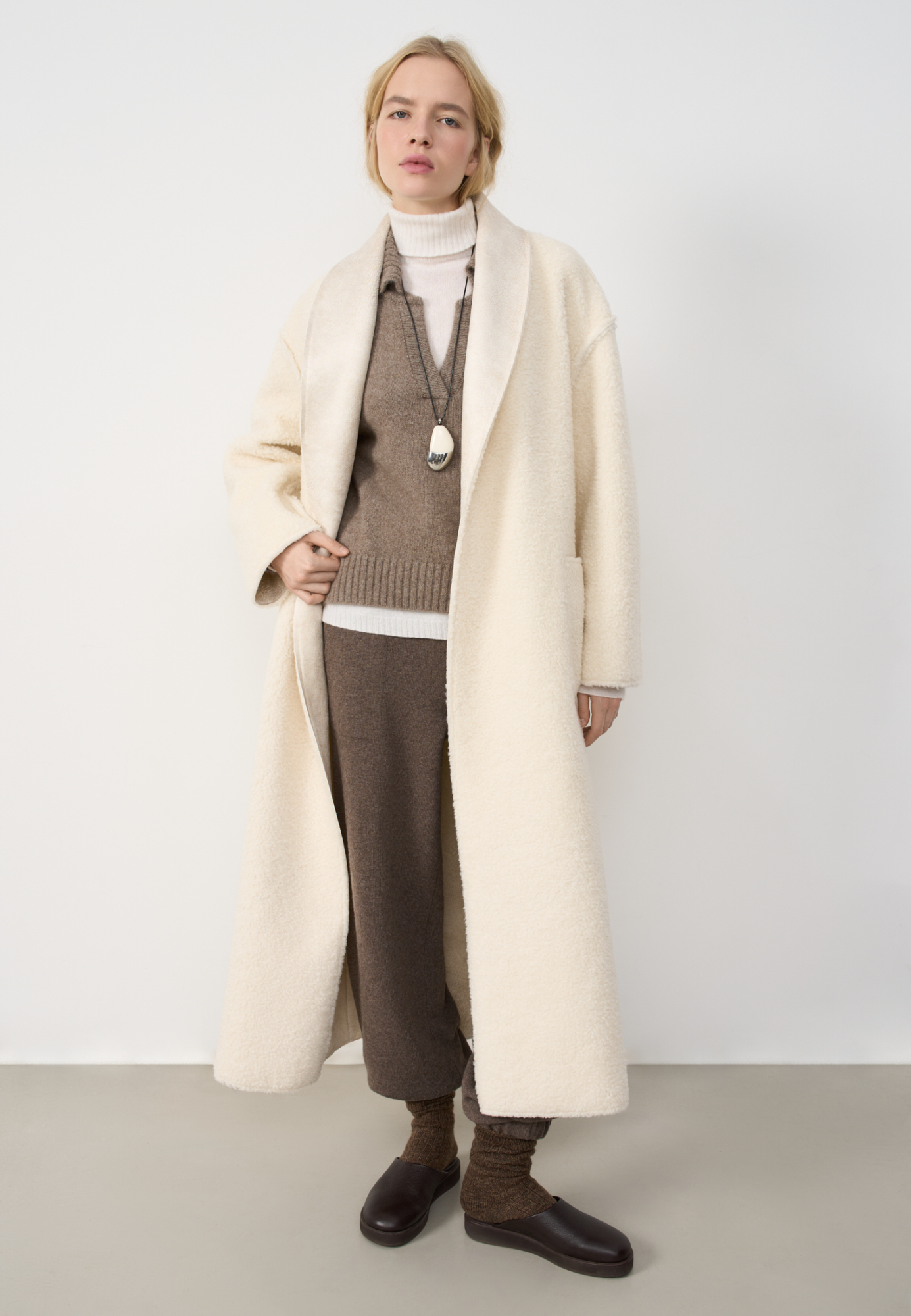 Двустороннее пальто-дубленка из шерсти. Модель прямого кроя на запах с узкими лацканами, большими накладными карманами и тонким поясом из экокожи.