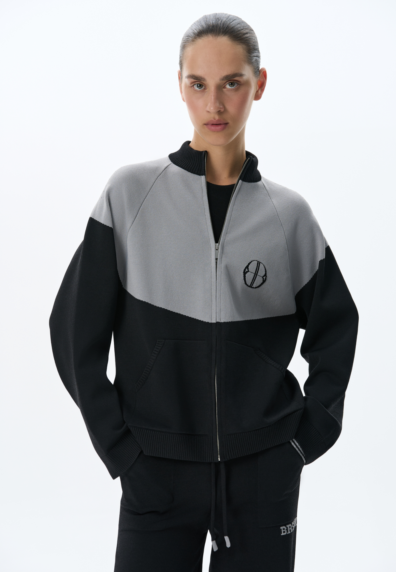 Трикотажный бомбер из вискозы с добавлением эластана. Модель прямого силуэта, с рукавом реглан, невысоким воротником-стойкой и боковыми карманами. Изделие декорировано брендированным жаккардом на груди. Застежка на молнию.