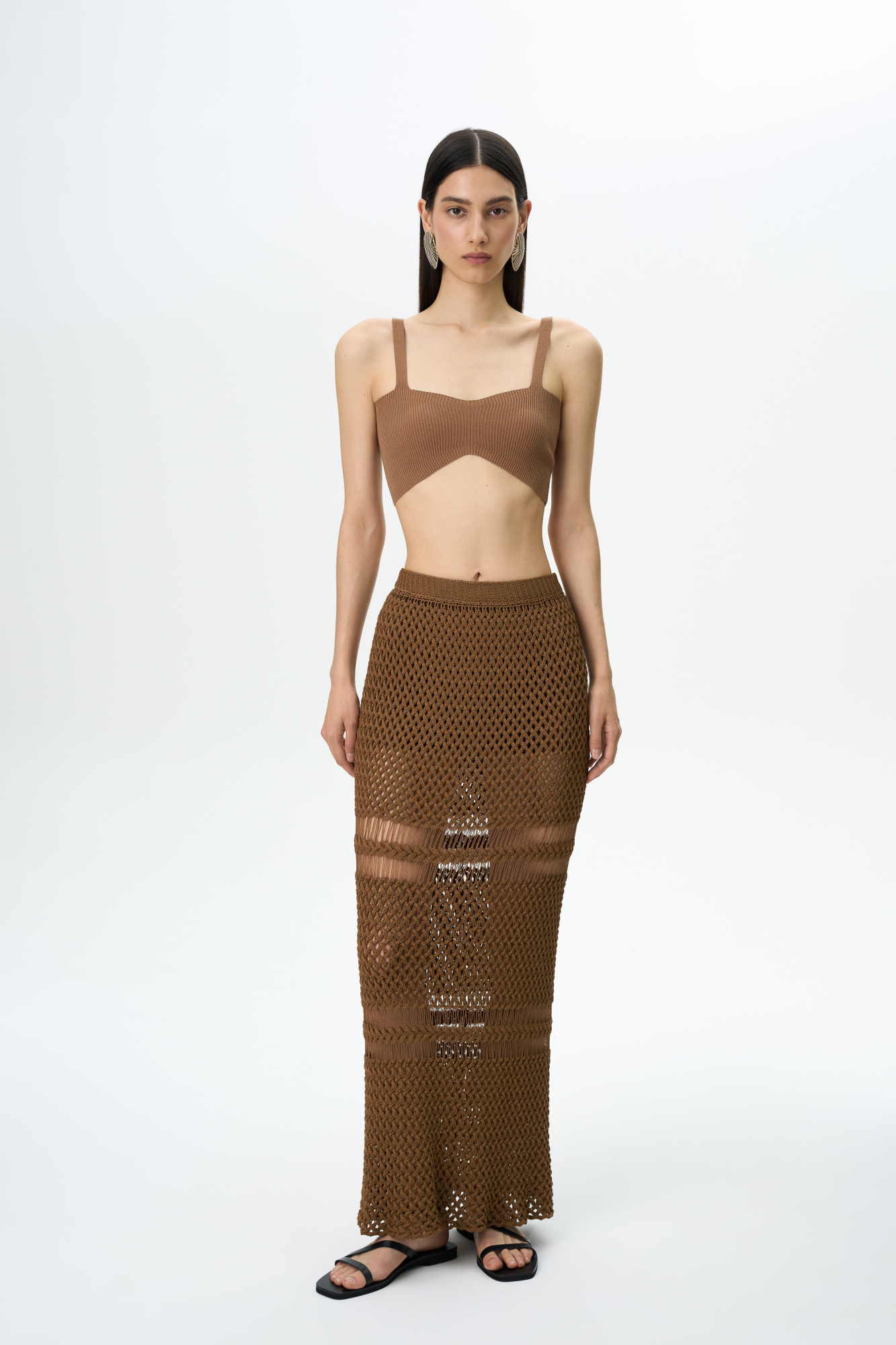 Трикотажная юбка длины макси. Модель приталенного силуэта, выполненная сложным ажурным переплетением с протяжками. 