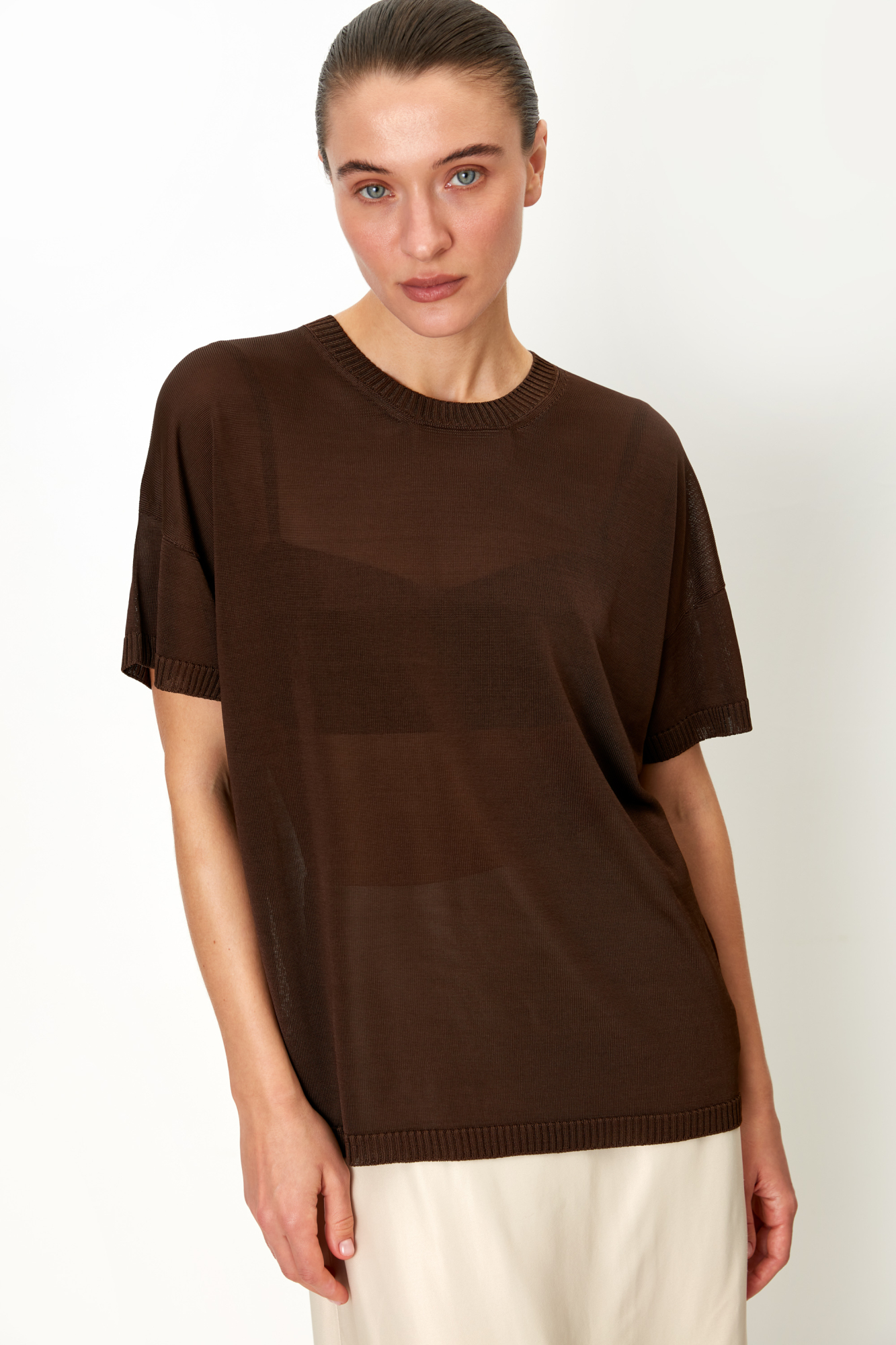 Цельновязаная футболка из 100% вискозы. Модель свободного силуэта, со спущенной линией плеча и круглым вырезом горловины. Края изделия выполнены в рубчик.