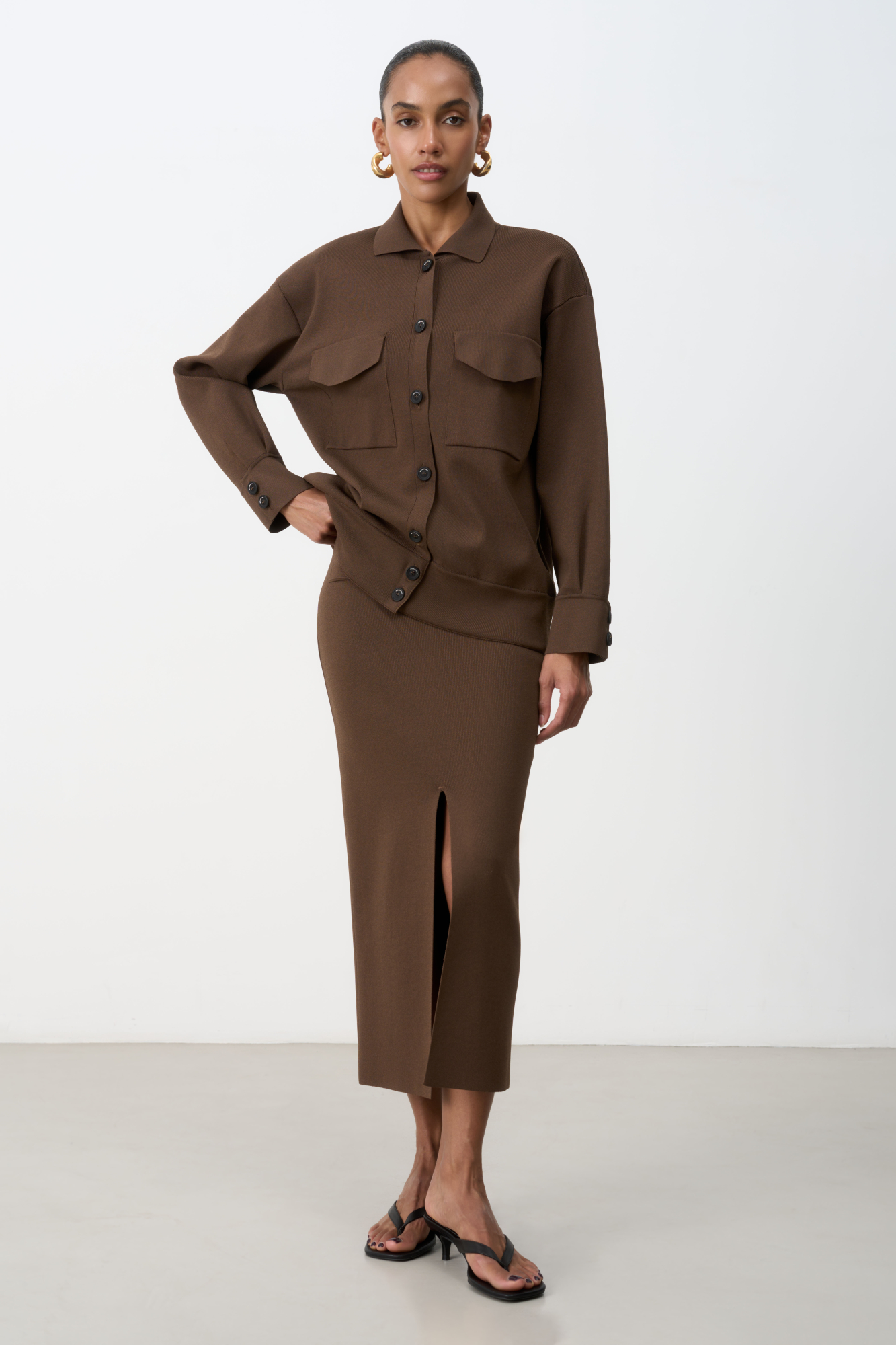 Трикотажная юбка-карандаш длины миди из вискозы. Модель приталенного силуэта с разрезом спереди, задними карманами и широким эластичным поясом.