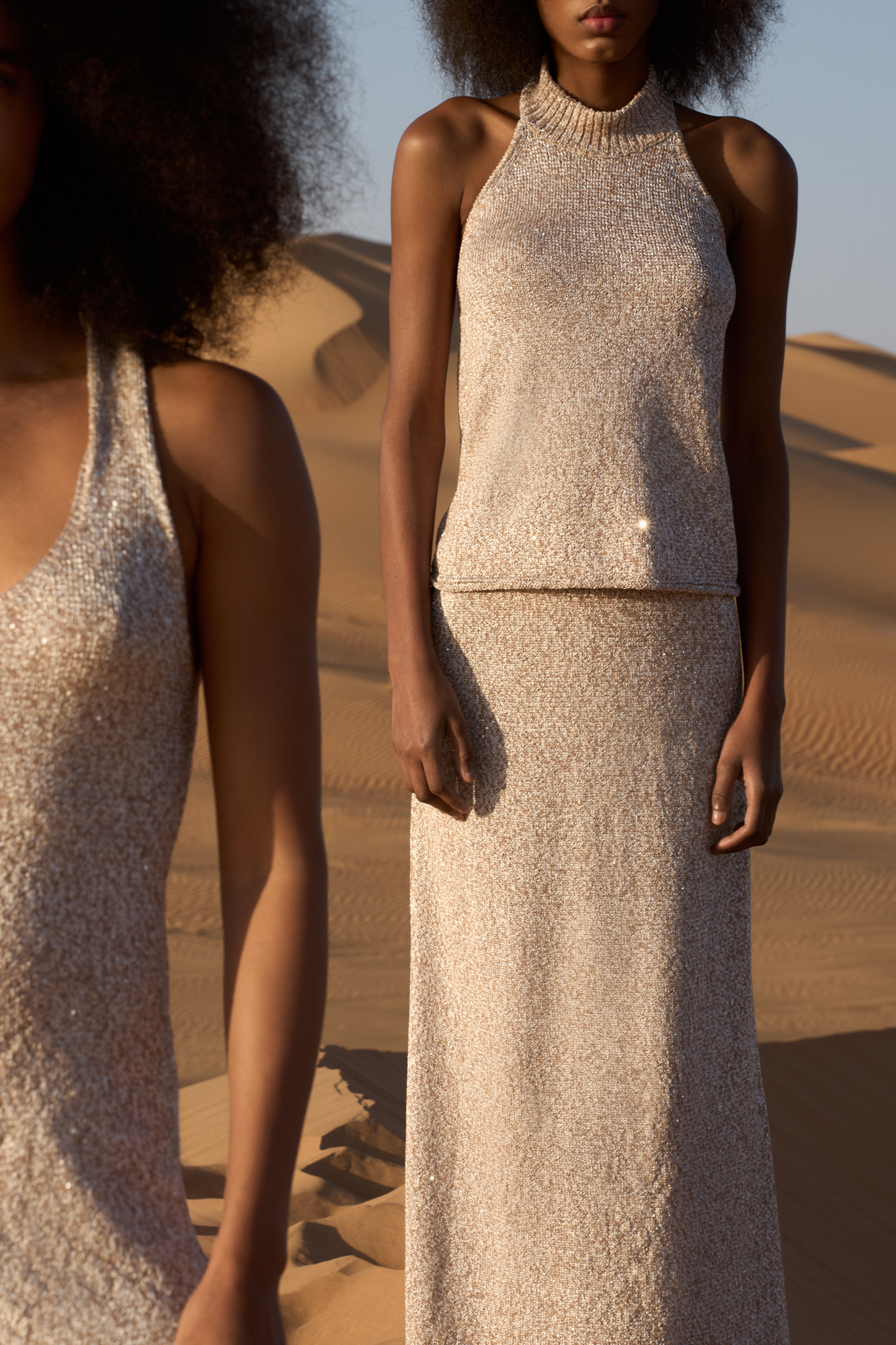 Трикотажный топ из хлопка с пайетками. Модель свободного кроя с американской проймой, высоким воротом и открытой спинкой. 