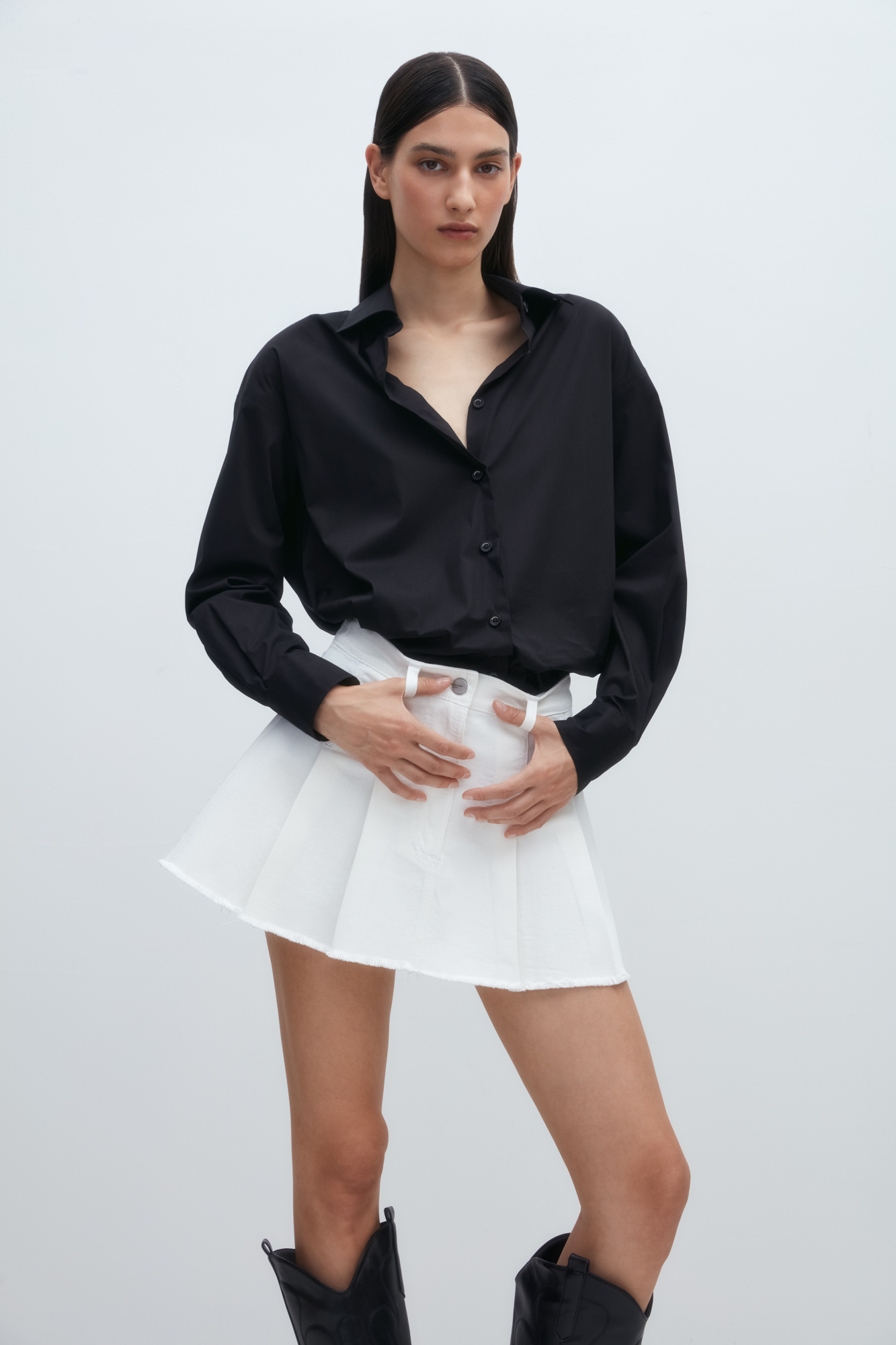 Джинсовая юбка длины мини в складку из хлопка. Потайная застежка на молнию и пуговицу. Шлевки на поясе для ремня.