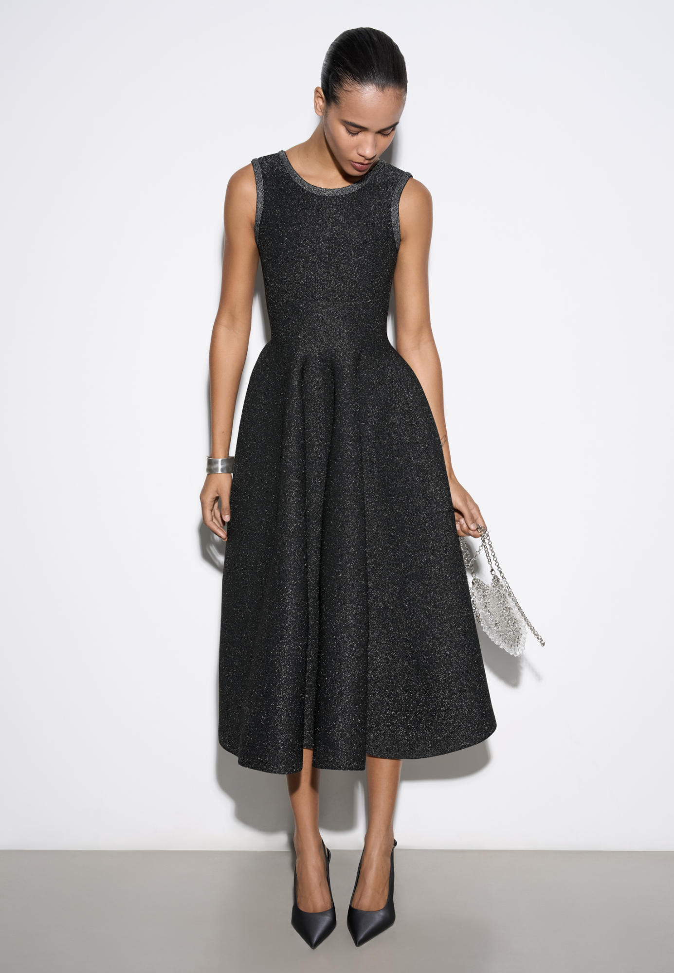Трикотажное платье длины миди с люрексом. Модель по фигуре с юбкой, расклешенной от талии, без рукавов, на широких бретельках.