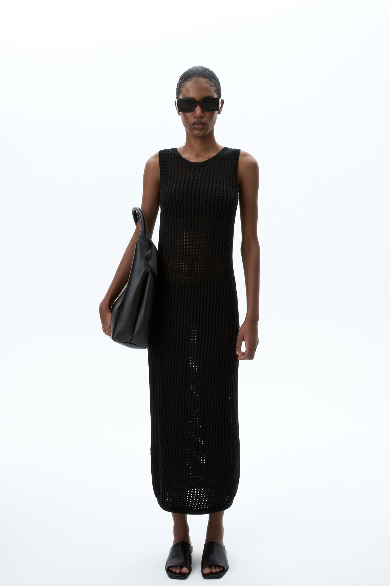 Трикотажный сарафан из хлопка с добавлением эластана, выполненный ажурной вязкой. Модель прямого силуэта, без рукавов, с глубокой проймой и круглым вырезом горловины.