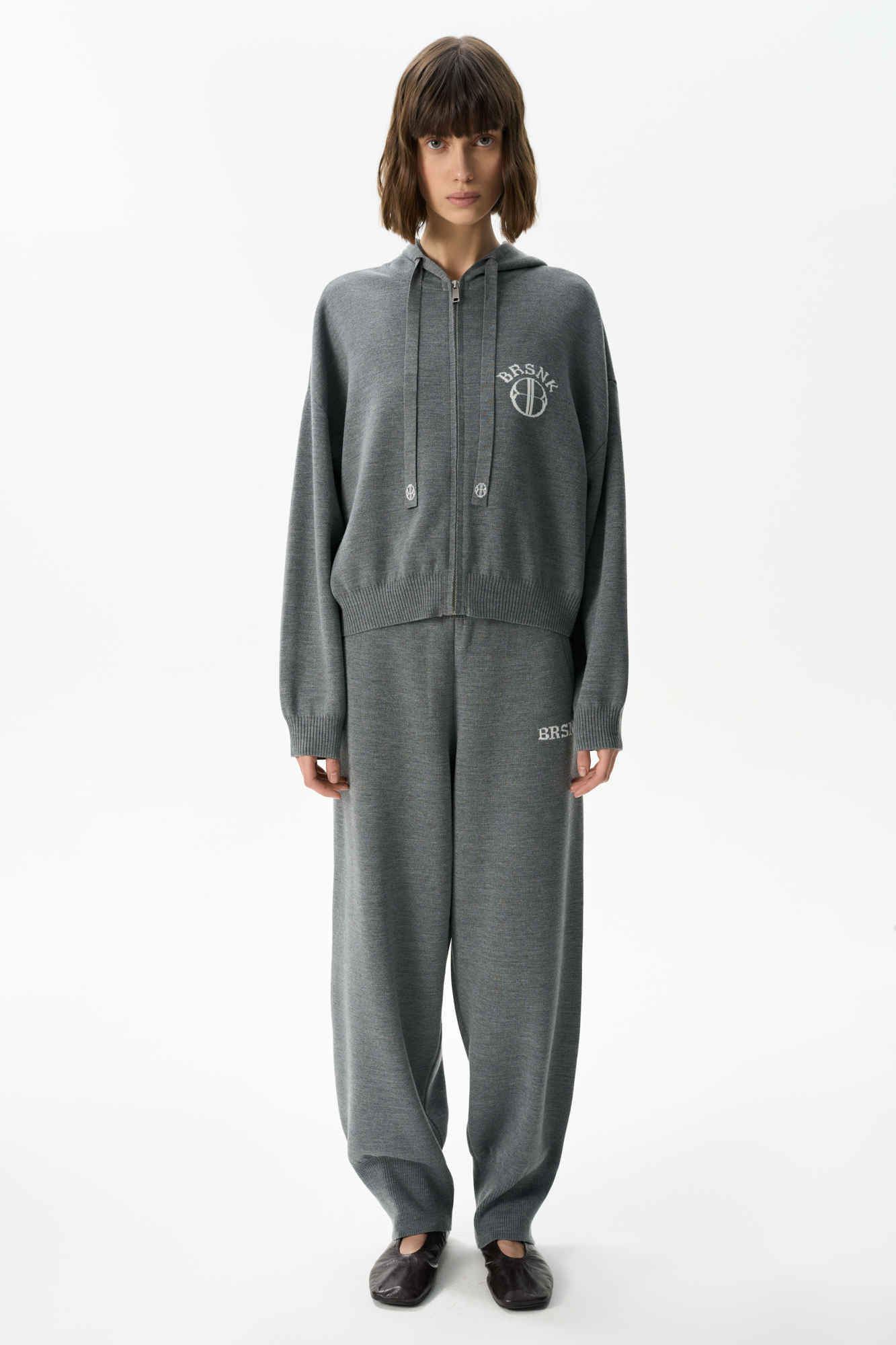 Трикотажные брюки из шерсти с добавлением акрила. Модель выполнена в спортивном стиле, с широким эластичным поясом на кулиске, боковыми карманами и широкими манжетами на резинке. Изделие декорировано брендированным жаккардом на штанине.