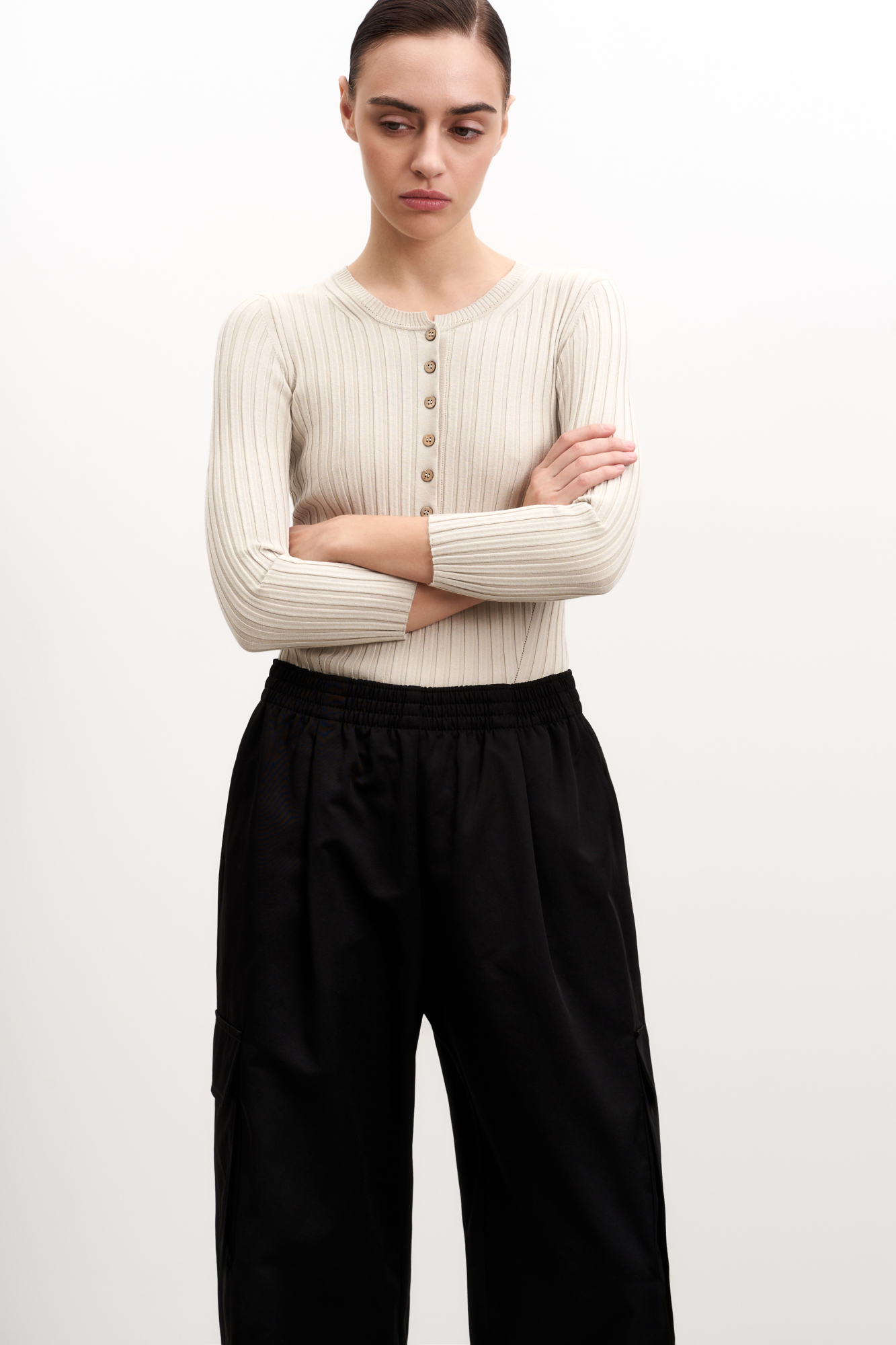 Трикотажный топ из вискозы в широкий рубчик. Модель с рукавами 3/4 и вырезом горловины с планкой на пуговицах, создающим V-образный вырез.