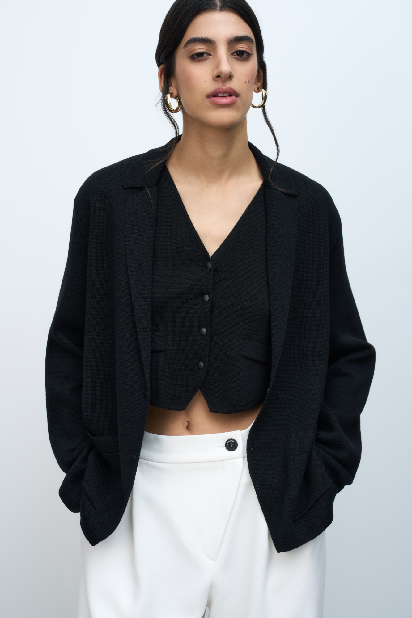 Трикотажный однобортный жакет из шерсти мериноса. Модель свободного силуэта, с узкими лацканами и двумя накладными карманами. Застежка на две кнопки. Дополнить образ можно жилетом, юбкой или брюками.