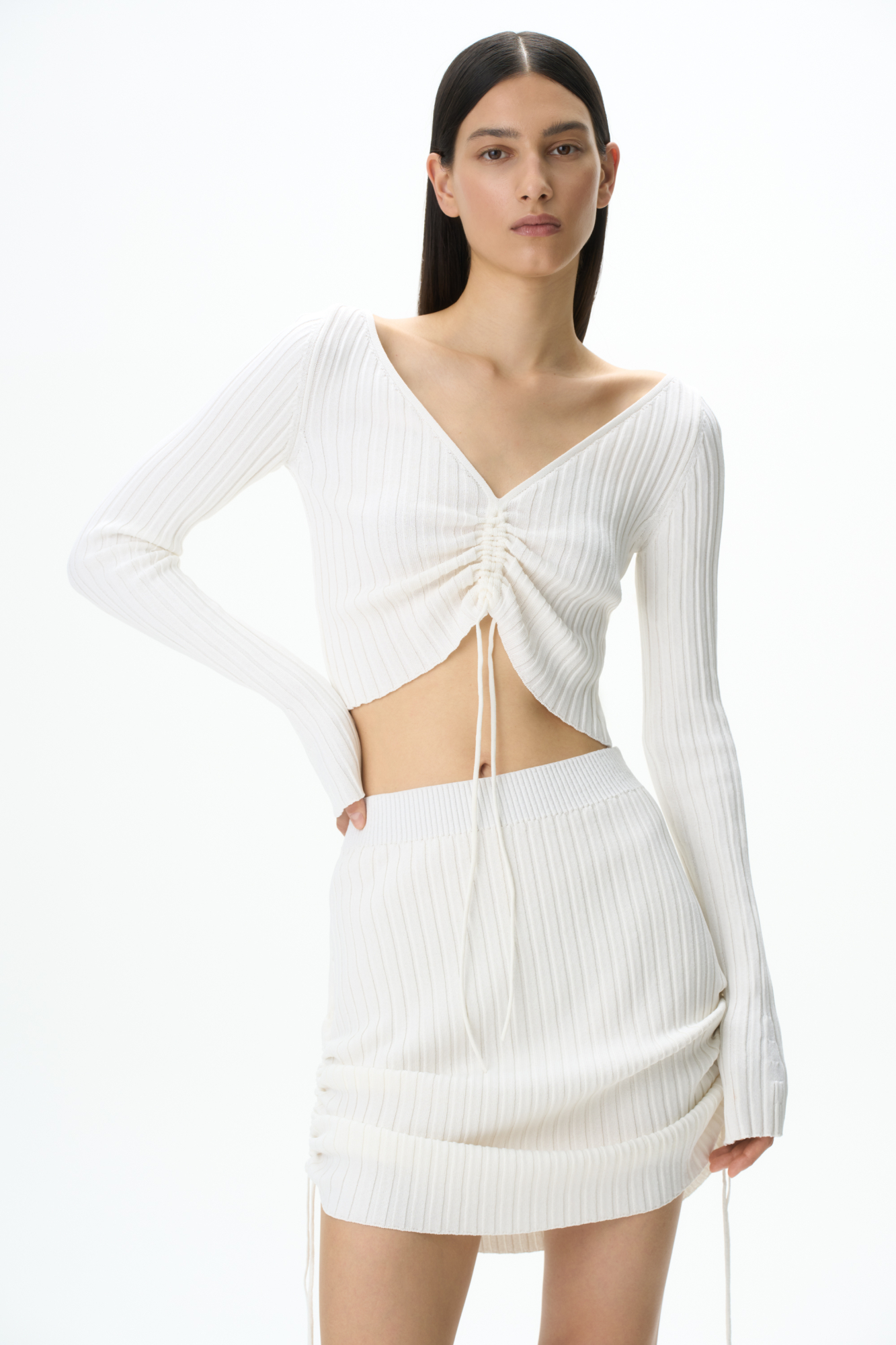 Трикотажный топ из вискозы с длинным рукавом. Модель с V-вырезом и регулируемой кулиской спереди.