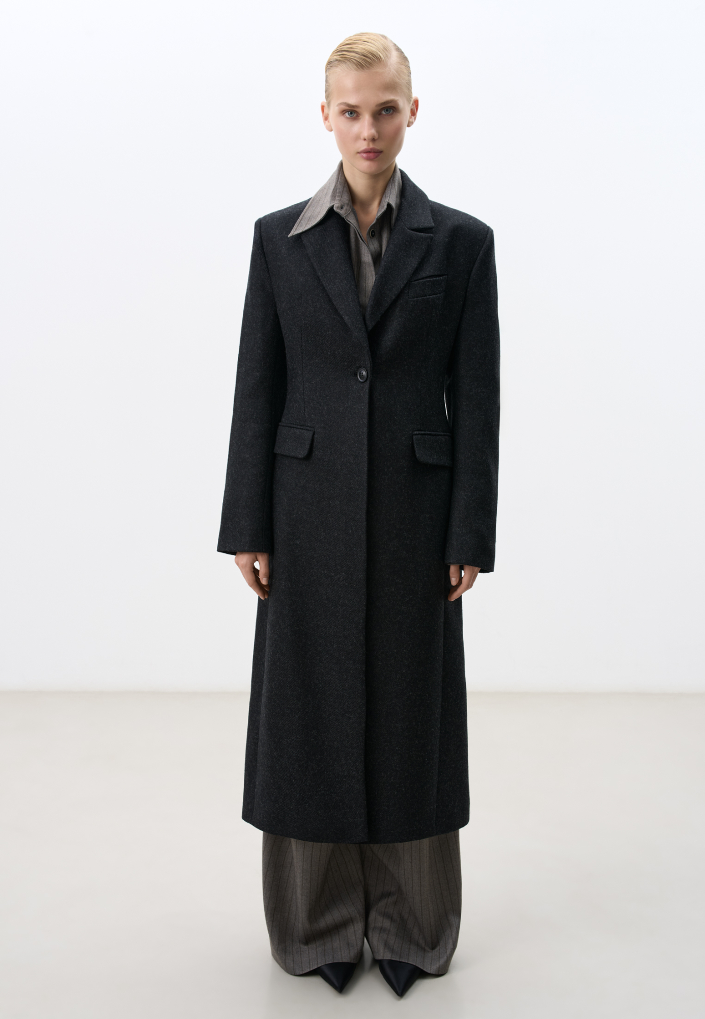Классическое однобортное пальто из шерсти. Модель приталенного силуэта с широкими лацканами и карманами с клапанами. Изделие на подкладке. Застежка на пуговицу.