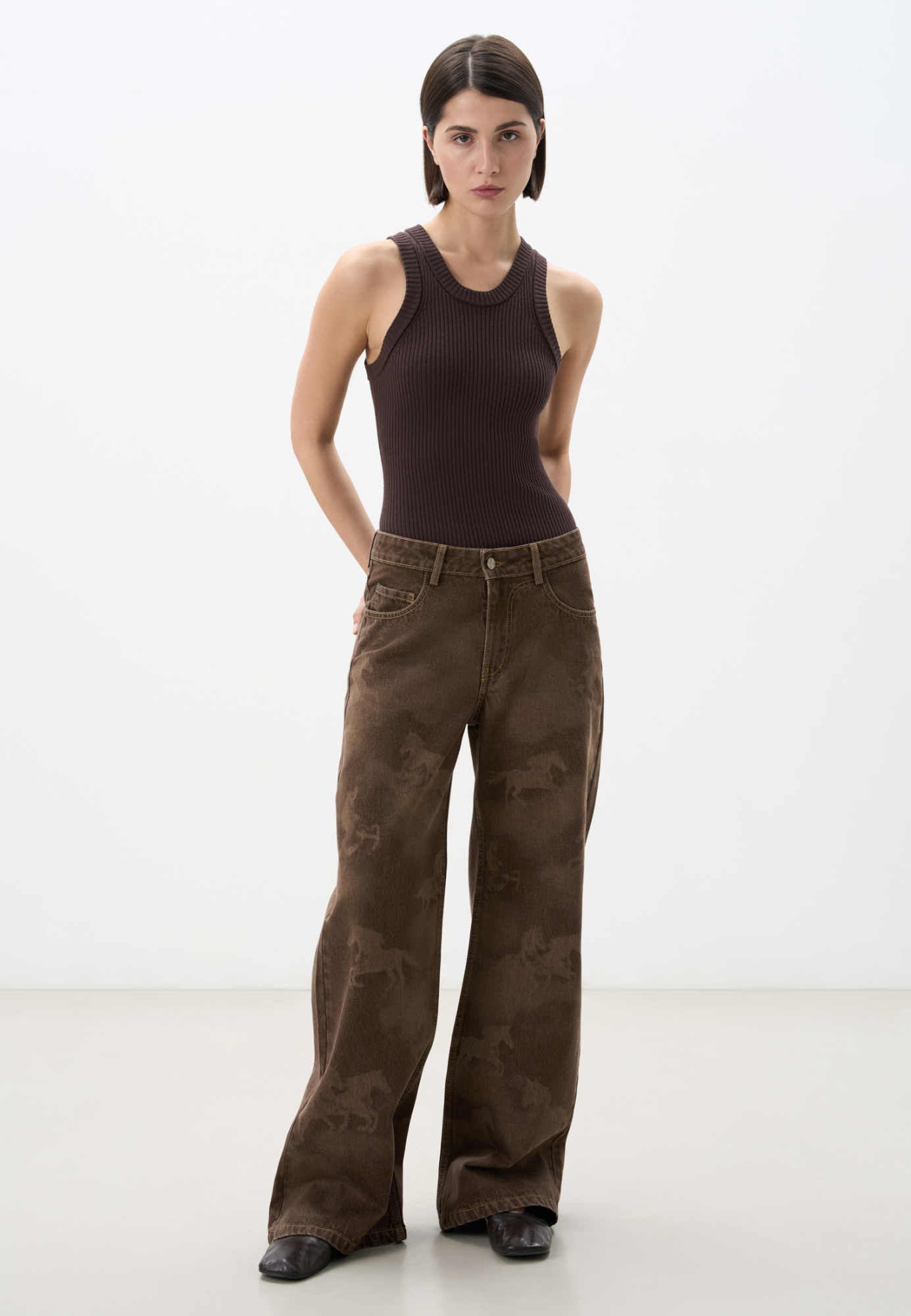 Джинсы из 100% хлопка с принтом в виде лошадей. Модель прямого кроя, с пятью карманами и шлевками на поясе для ремня. Застежка на молнию и пуговицу. Задние карманы выполнены в виде подковы.<br />
Модель в стиле дерби - направления в моде, которое имитирует одежду для скачек. 