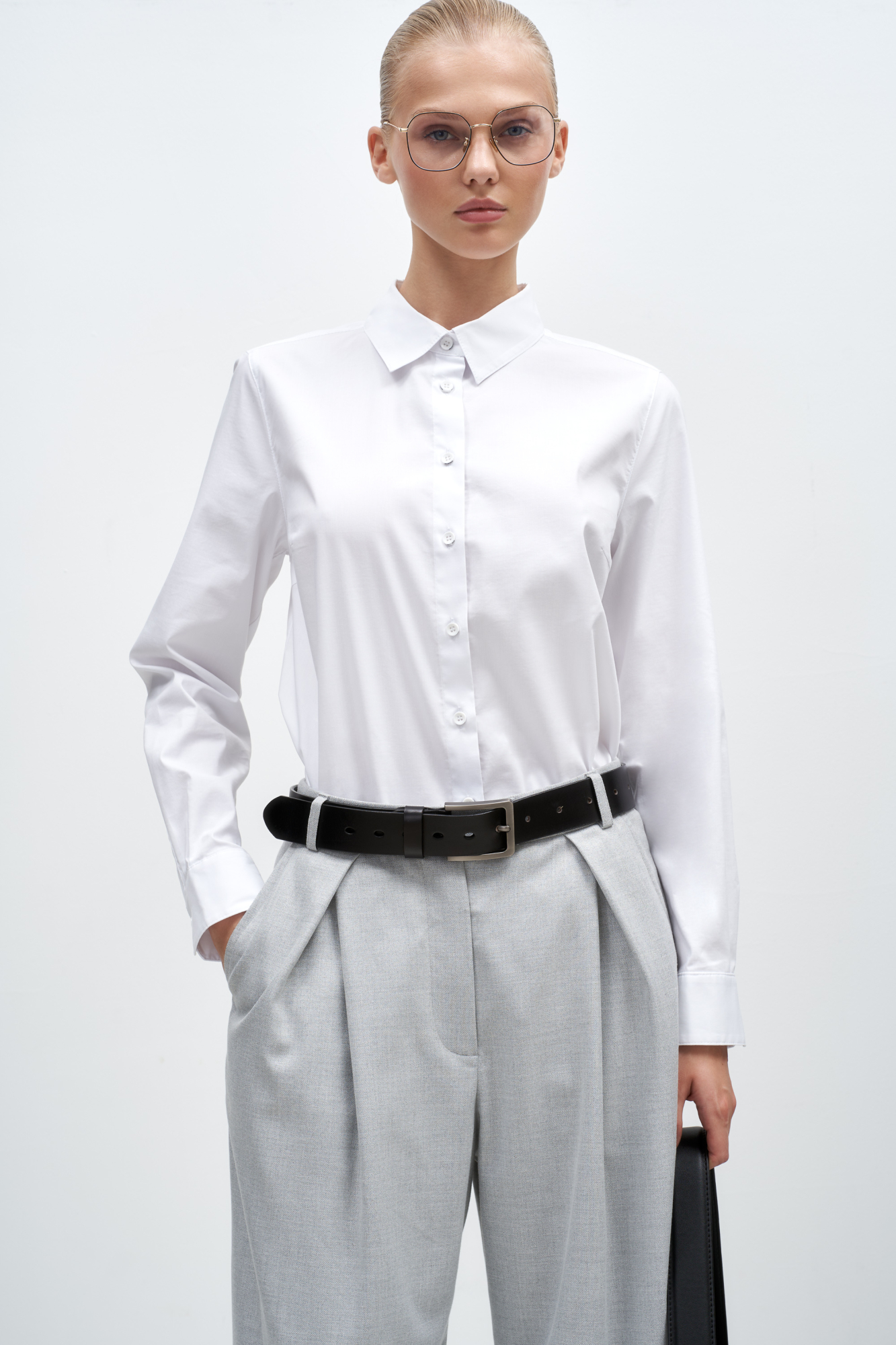 Классическая рубашка из хлопка. Модель прямого кроя, с длинными рукавами с манжетами, отложным воротником и застежкой на пуговицы.