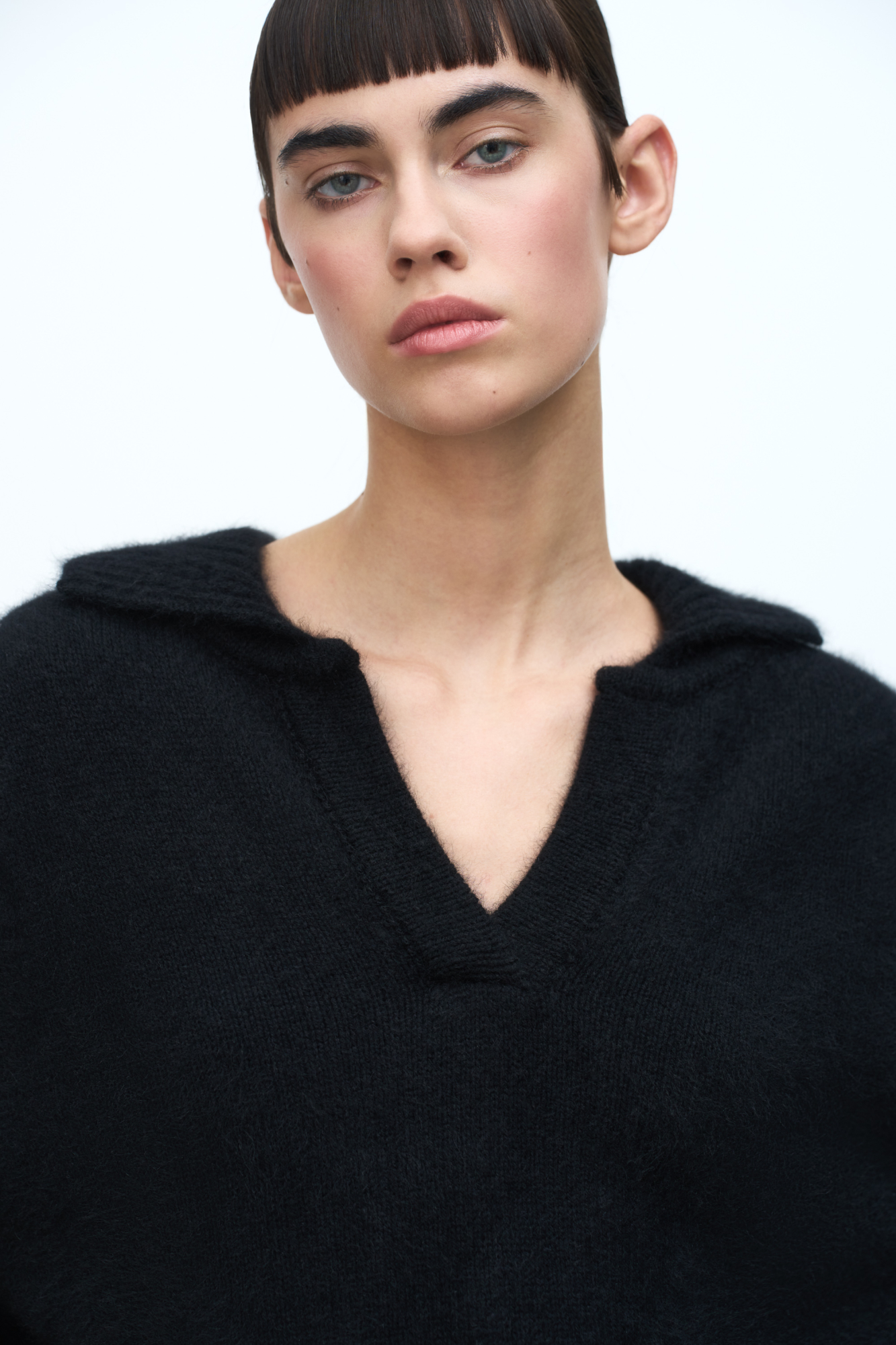 Трикотажный джемпер из смесовой шерсти с добавлением пуха лисы. Модель со спущенной линией плеча и отложным воротником с V-образным вырезом. Воротник, манжеты рукавов и низ изделия выполнены в рубчик.