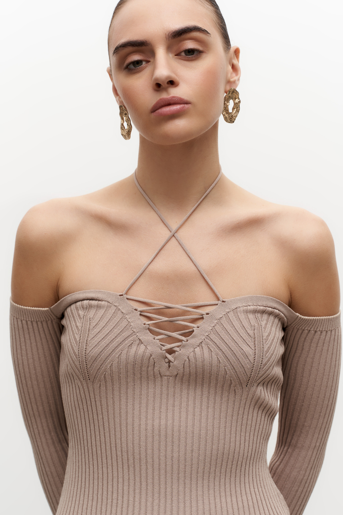 Трикотажные топ из вискозы. Модель с длинными рукавами, разрезами по бокам и глубоким декольте со шнуровкой.